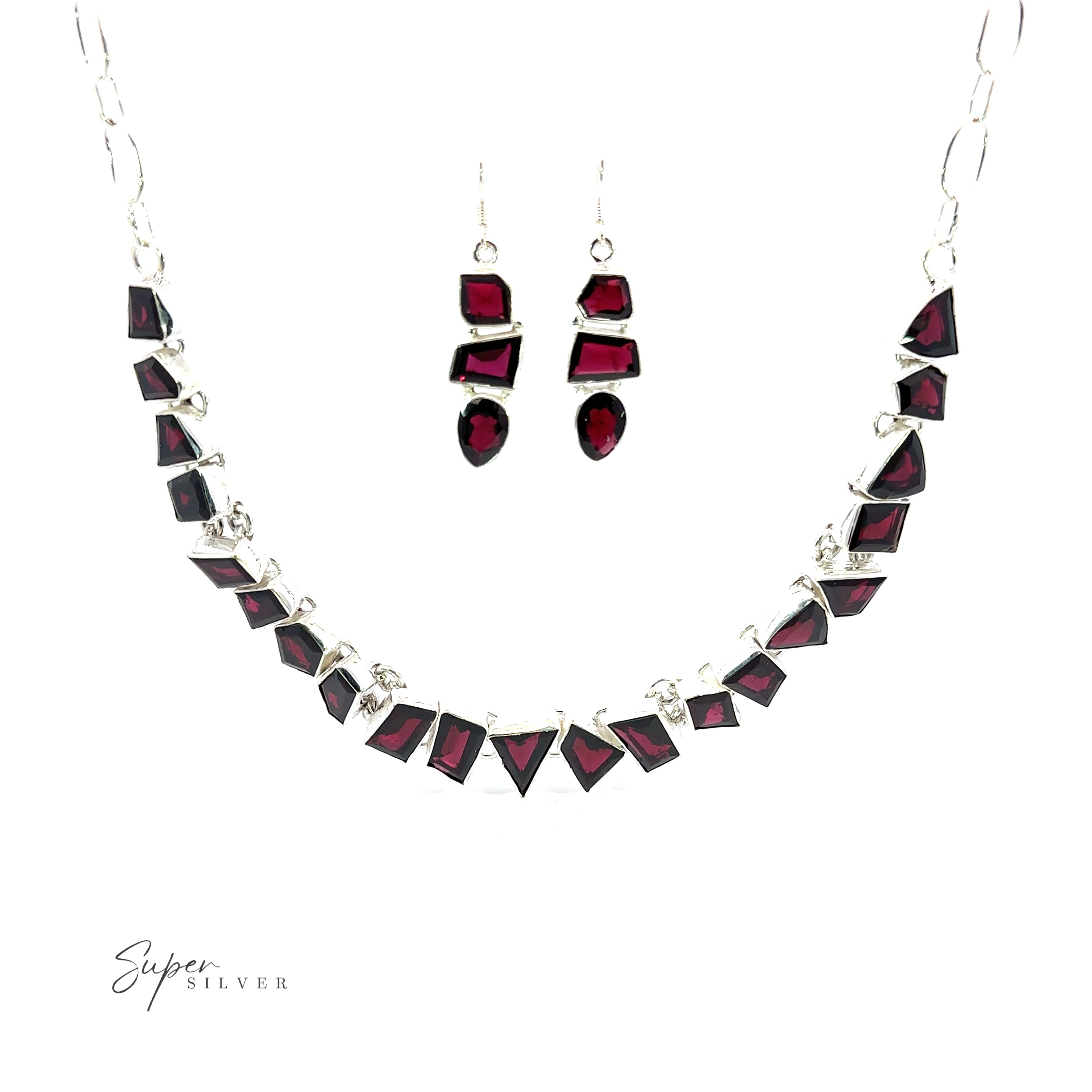 A Statement Gemstone Necklace and a pair of earrings with rich garnet stones set in silver, displayed on a white background. The necklace features geometric-shaped gemstones, and the earrings have a matching design, creating an elegant coordinated set.