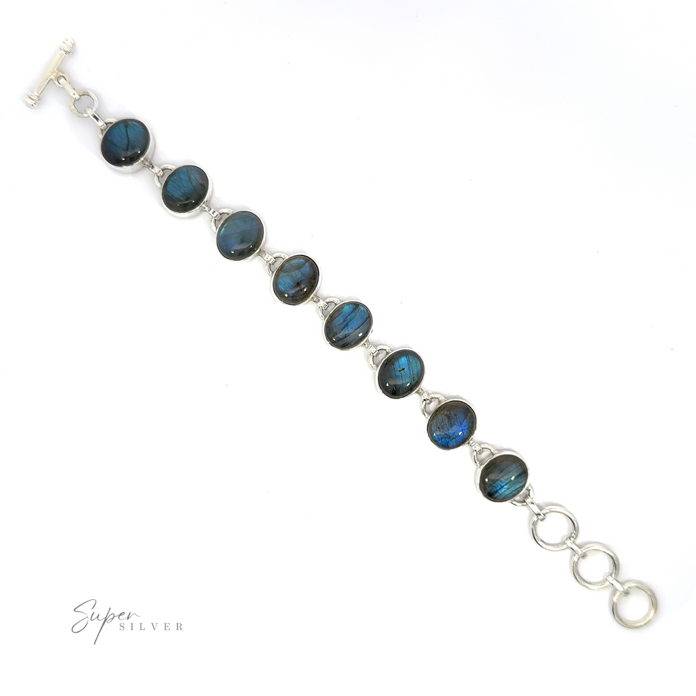 
                  
                    A silver Statement Oval Gemstone Bracelet featuring blue labradorite stones with a clasp closure, displayed against a white background.
                  
                