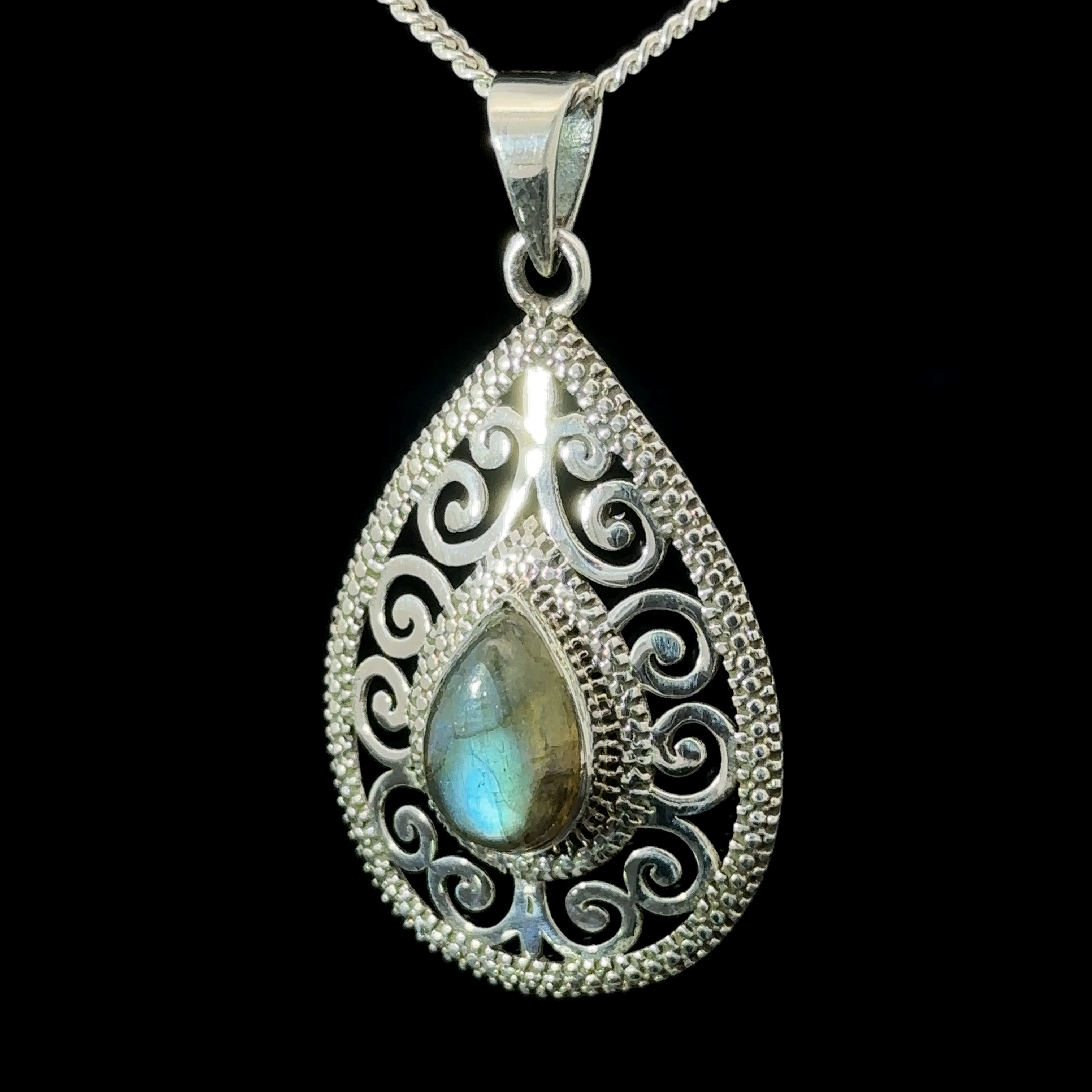 Gemstone Teardrop Pendant with Swirls, featuring a central iridescent Labradorite stone, hanging on a matching sterling silver chain against a black background.