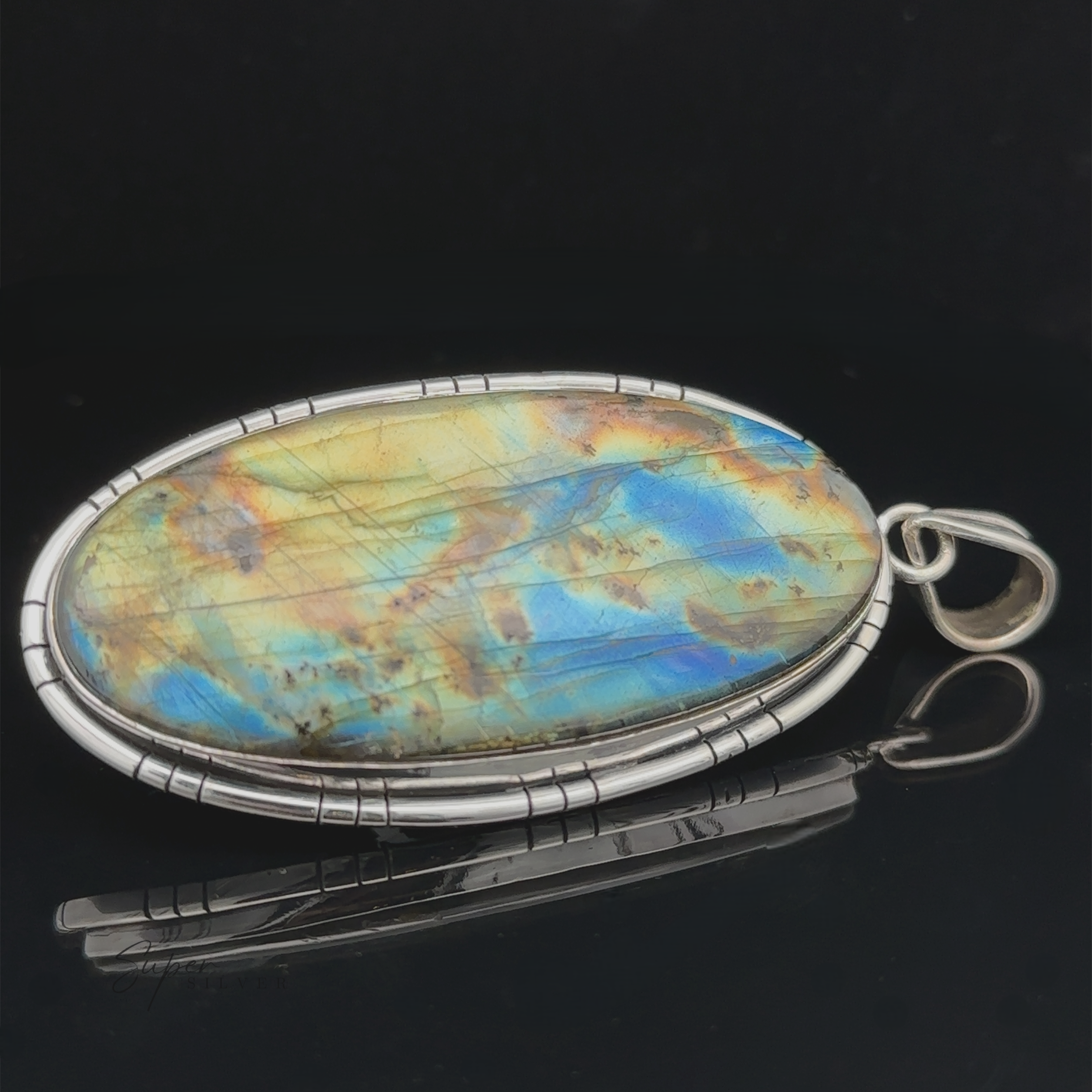 An XL Statement Oval Labradorite Pendant set in a sterling silver jewelry frame, displayed against a black background.