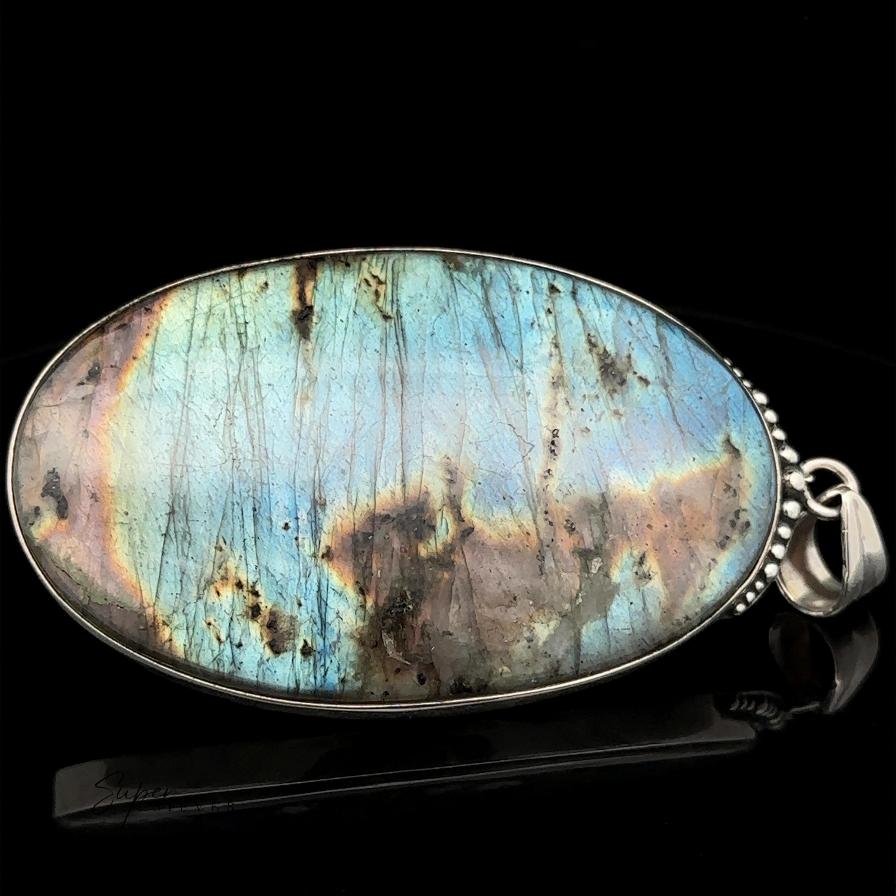 Oval-shaped labradorite pendant with a metallic sheen in shades of green, blue, and brown, set in sterling silver and displayed against a black background. This XL Statement Oval Labradorite Pendant is perfect for those who appreciate statement pendants as part of their jewelry collection.