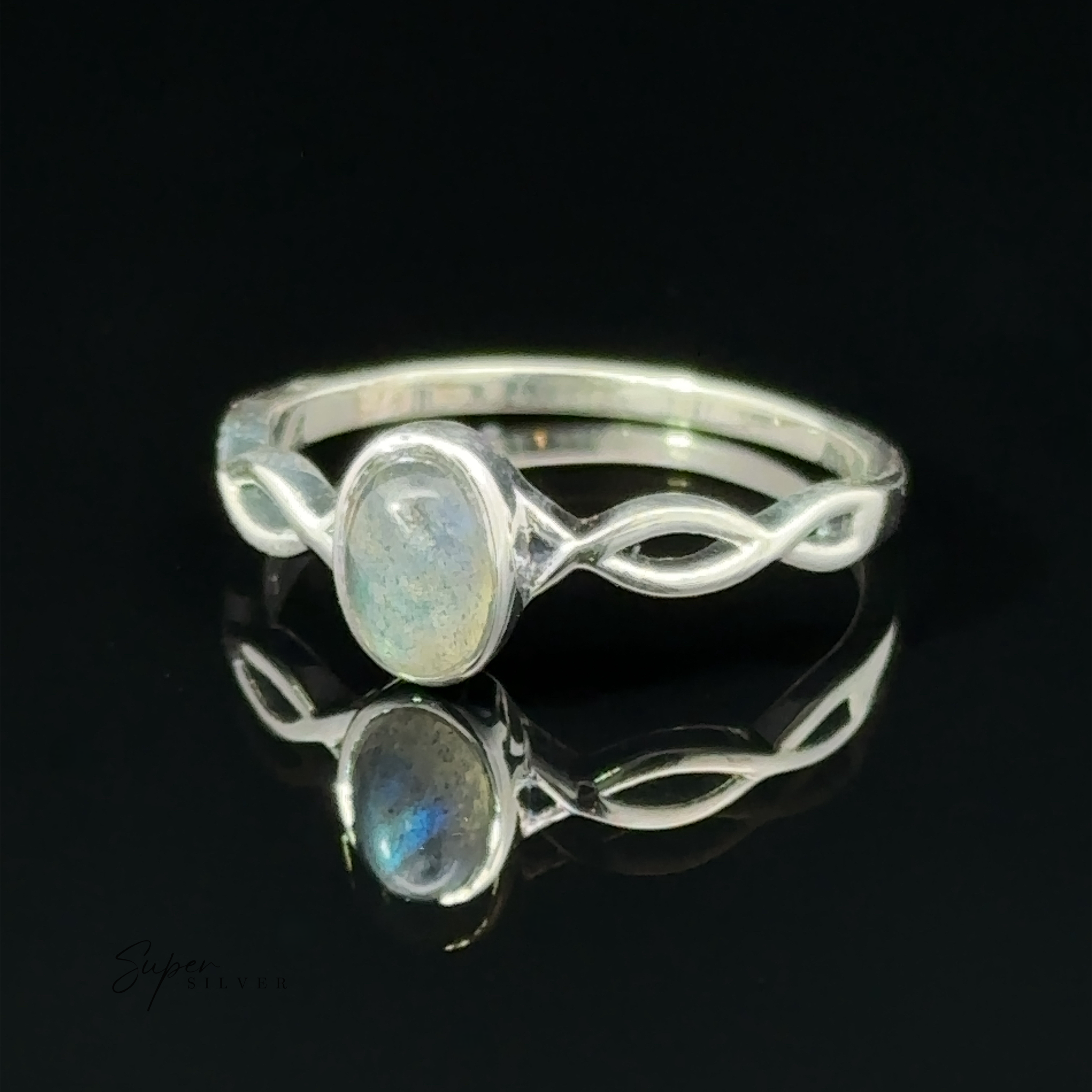 An elegant silver Dainty Oval Gemstone Ring with Twisted Band, reflected on a glossy black surface.