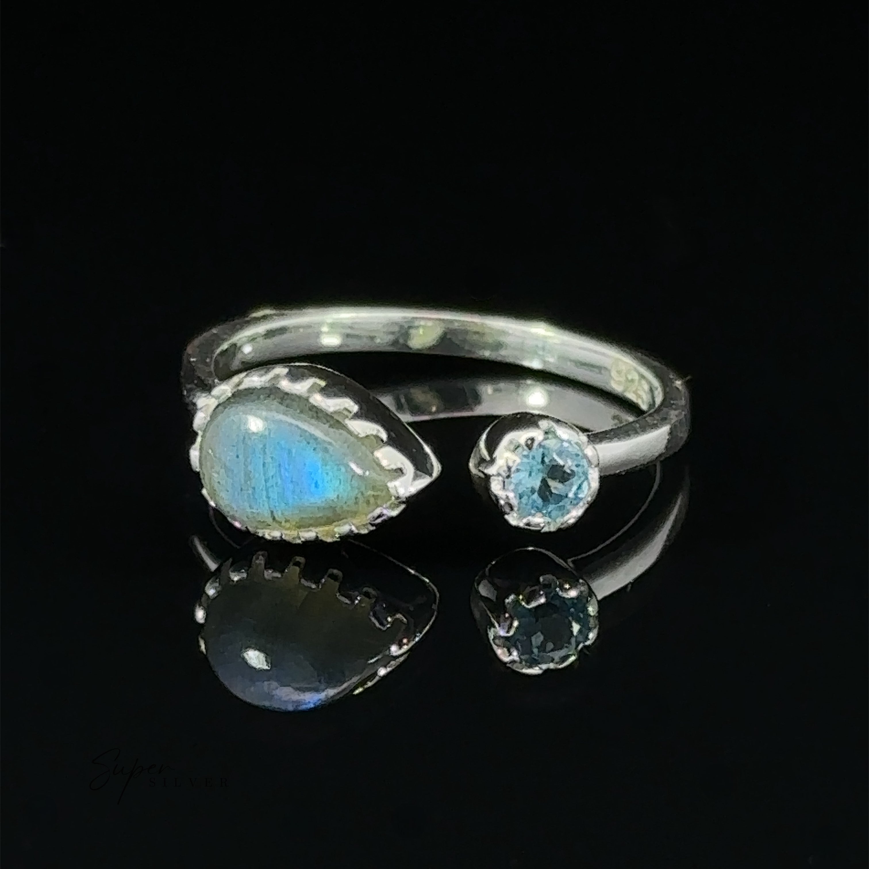 Dainty Adjustable Gemstone Ring with Two Stones with a pearlescent oval gemstone and two smaller clear crystals, set against a black background.