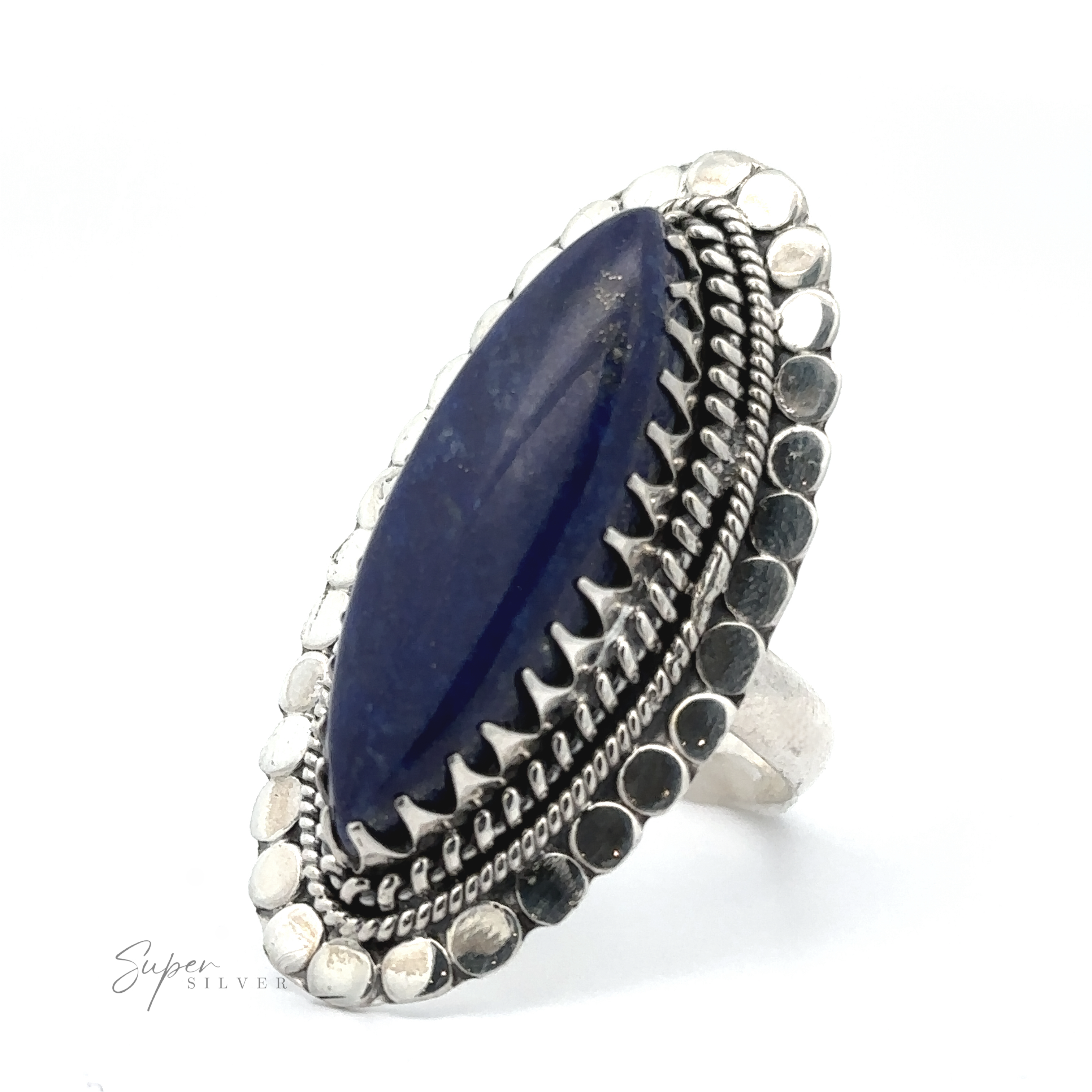 A silver ring with a marquise-shaped blue gemstone is displayed against a white background. The band features intricate detailing and a beaded border, embodying the essence of bohemian jewelry. The product name for this beautiful piece is Statement Marquise Shaped Gemstone Ring.