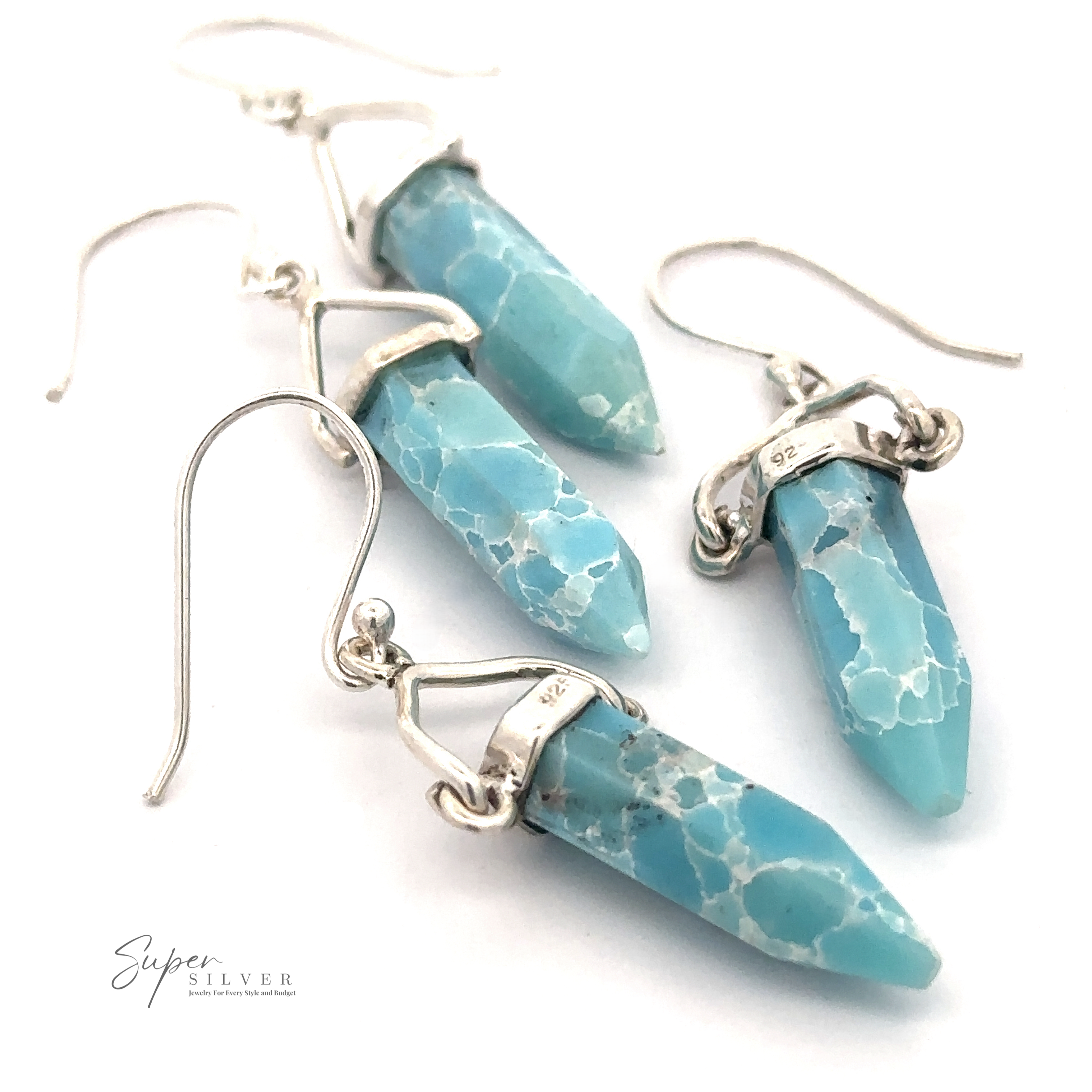 A pair of Obelisk Shape Raw Larimar Earrings with French hooks. The elongated and faceted stones are elegantly set in sterling silver. The logo "Super Silver" is visible in the bottom left corner.