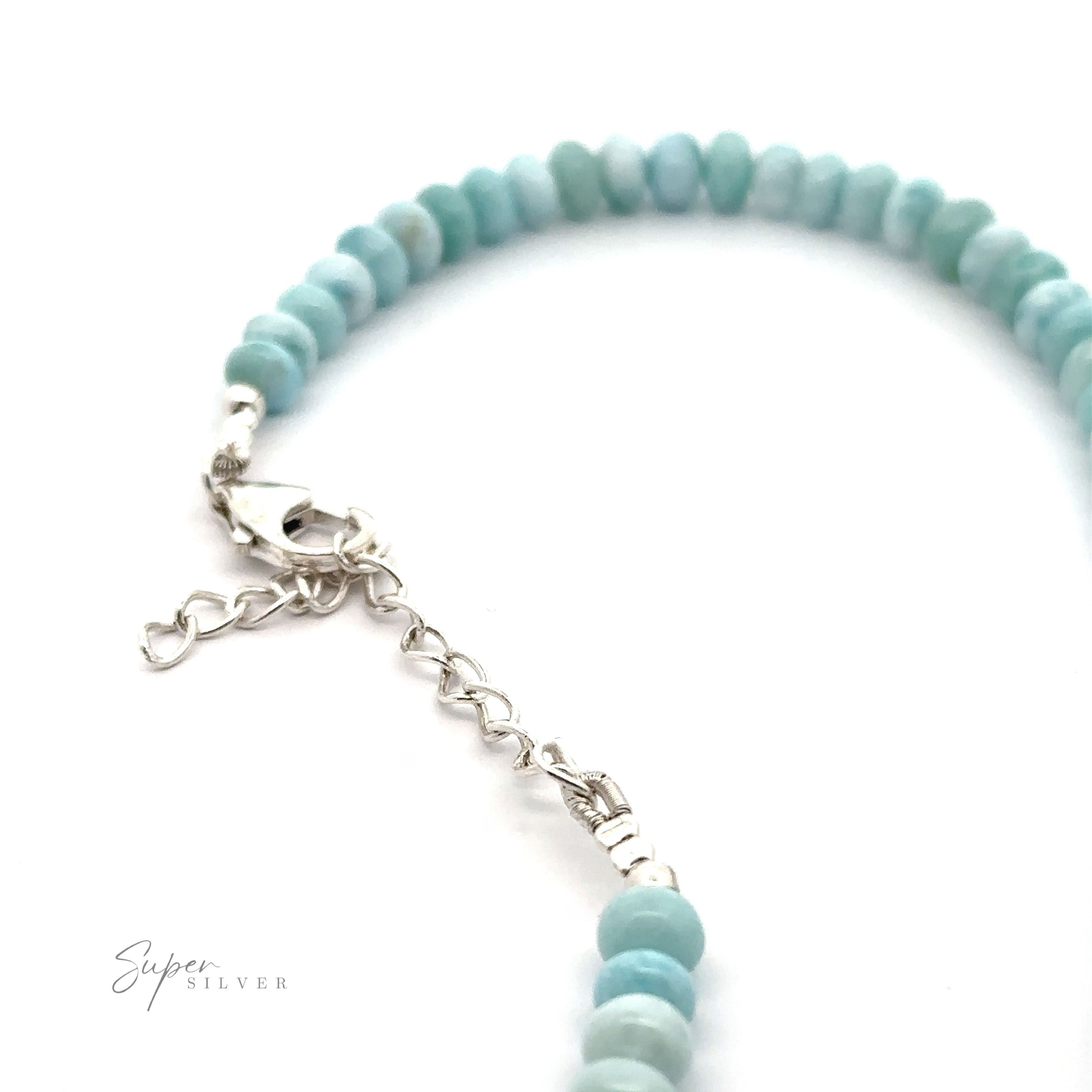 A close-up of a turquoise beaded necklace with a silver lobster clasp and an adjustable chain against a white background. The text "Larimar Beaded Necklace" is in the bottom left corner, showcasing this elegant piece reminiscent of a Larimar Beaded Necklace.