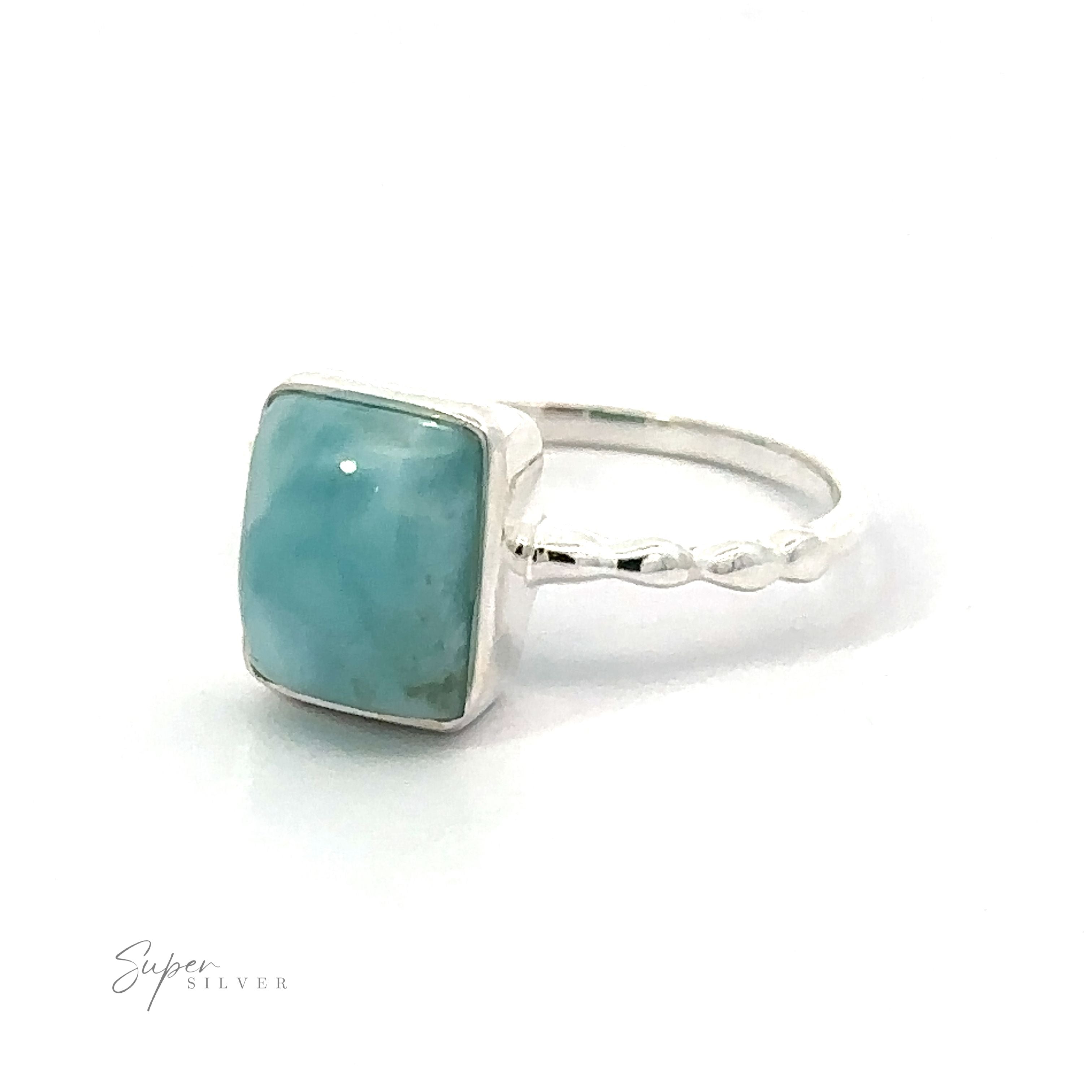 A .925 Sterling Silver ring with a rectangle aquamarine gemstone, featuring a beaded band, on a white background.