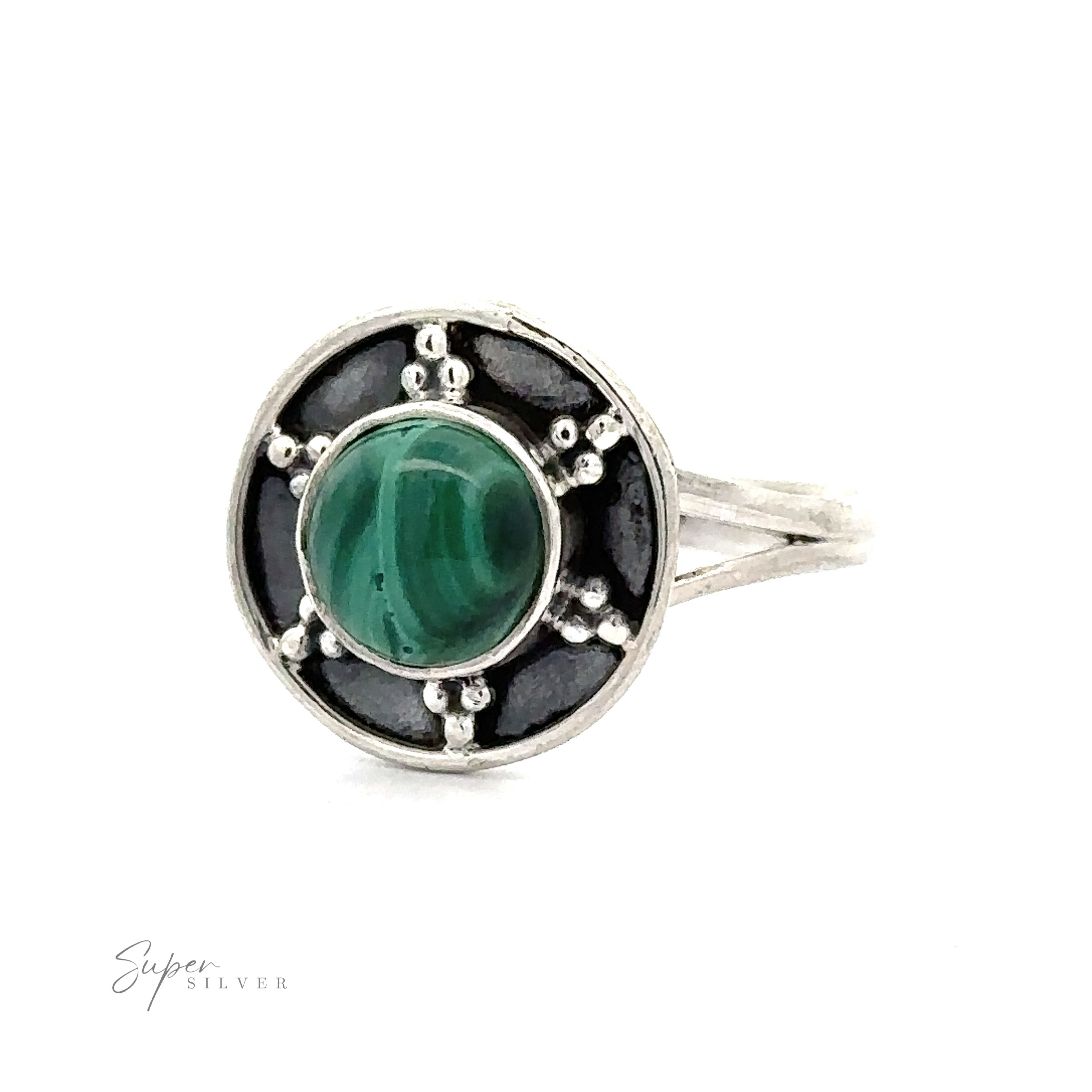 A Gemstone Ring With Unique Oxidized Design featuring a round green gemstone set in a circular pattern with black and oxidized silver accents, exemplifying exquisite Gemstone Jewelry.