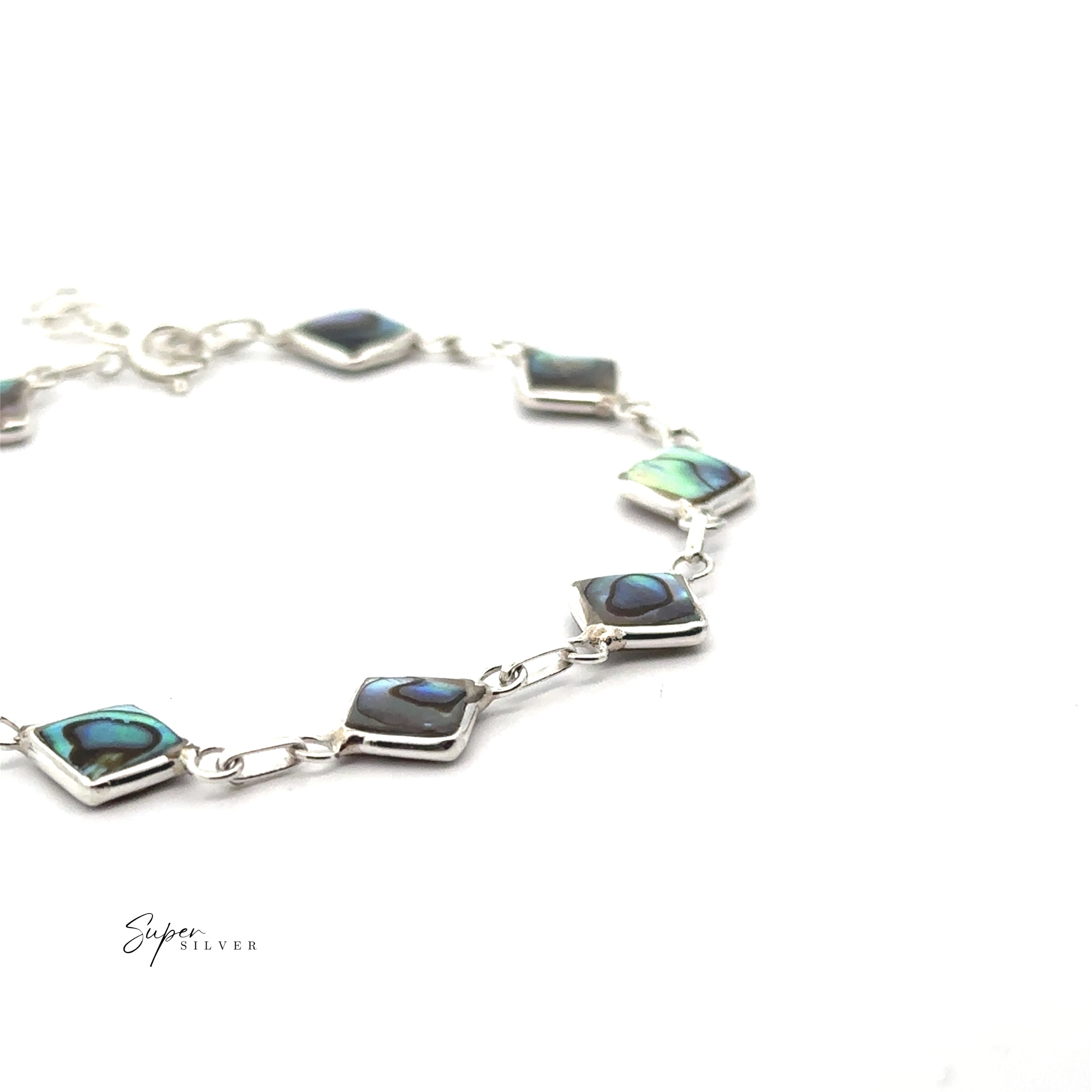 The Reversible Diamond Shaped Inlay Stone Bracelet, featuring sterling silver and abalone shell inlays, is a striking piece of jewelry shown on a white background.