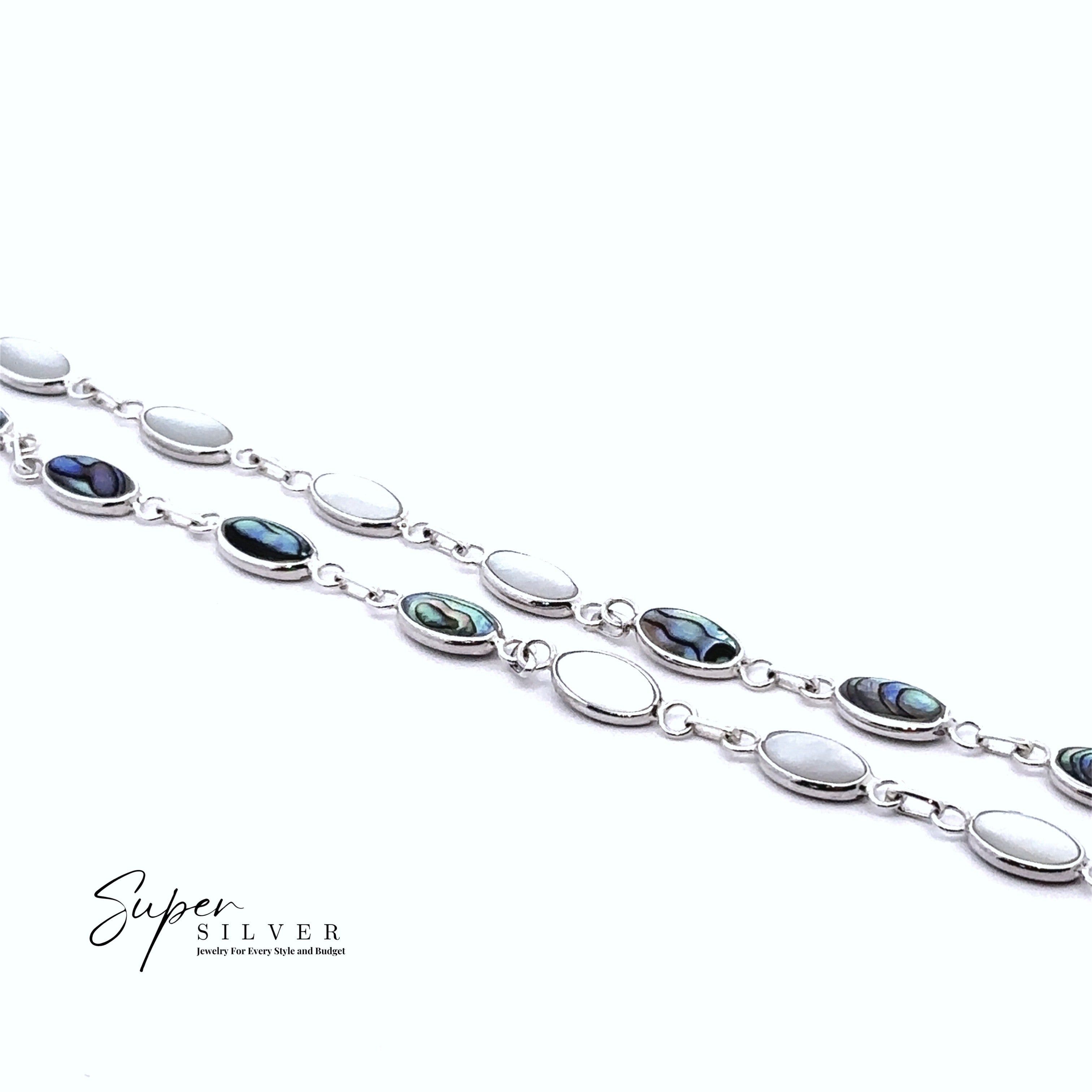 Two "Super Silver" Reversible Oval Shaped Inlay Stone Bracelets with silver chains—some links featuring shimmering abalone shell, others in plain silver—are displayed on a white background. Brand logo shown in the corner.