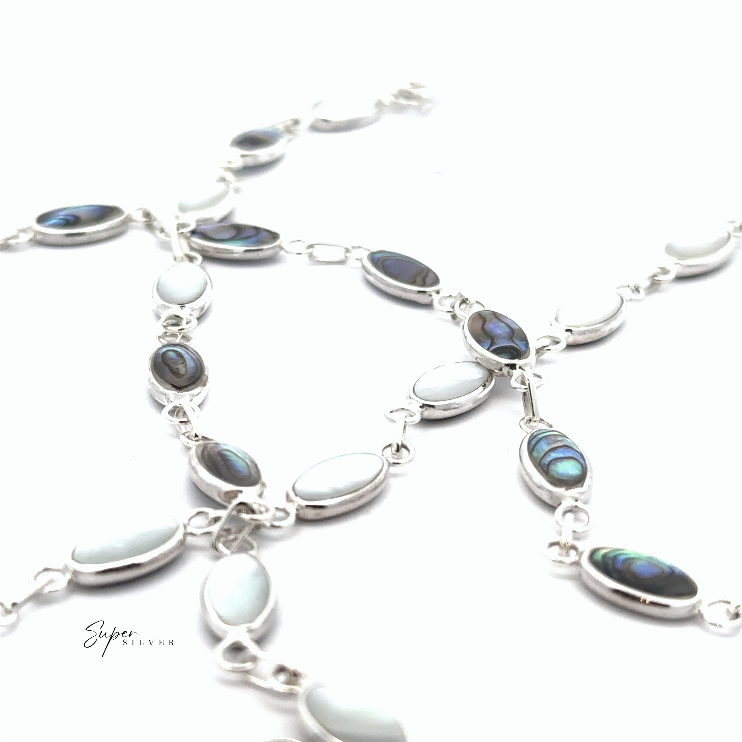 A close-up of the Reversible Oval Shaped Inlay Stone Bracelet with alternating abalone shell and white mother of pearl inlays on a silver chain, displayed against a white background.