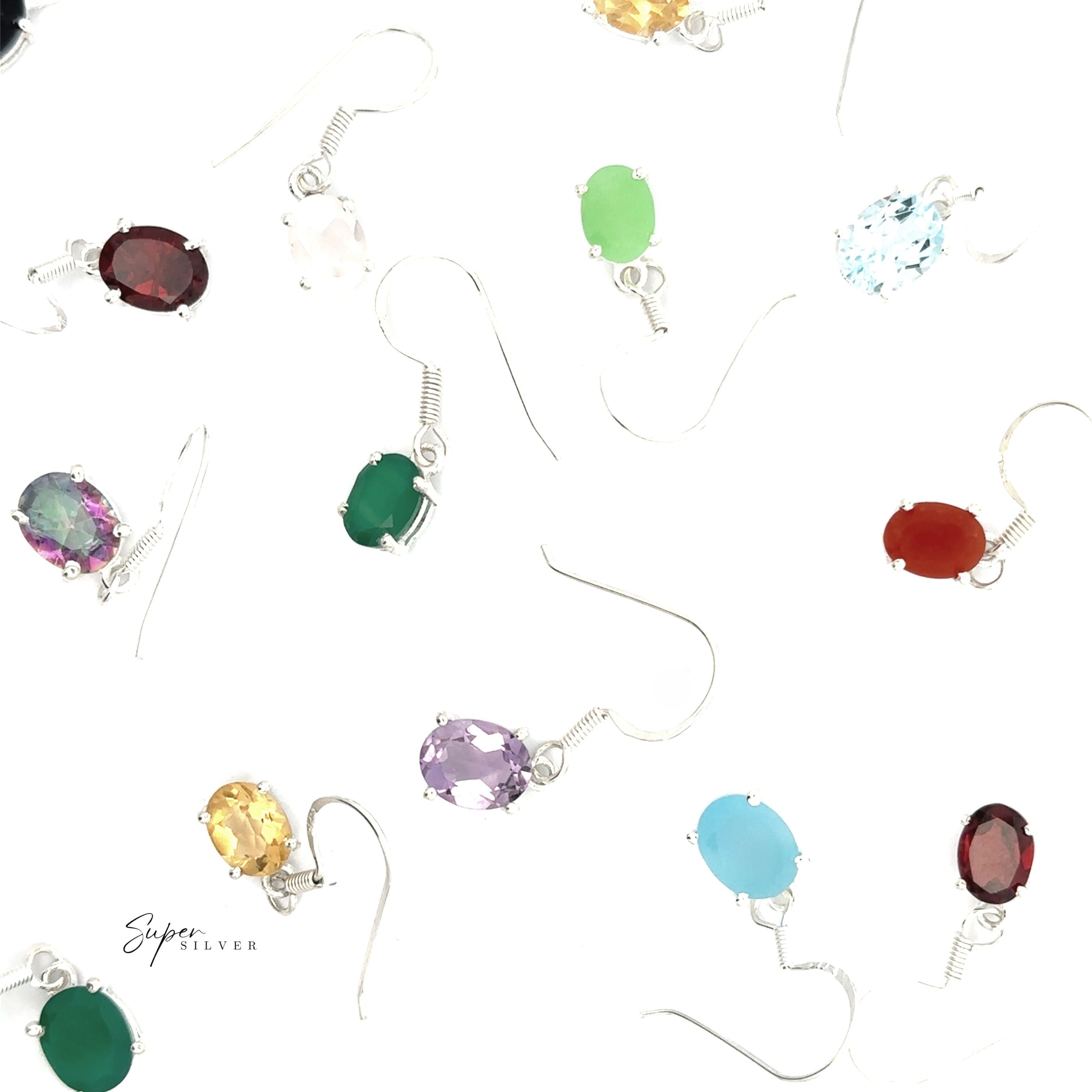 Brilliant Oval Gemstone Earrings in sterling silver, featuring prong-set gemstones in various colors, are elegantly displayed on a white background.