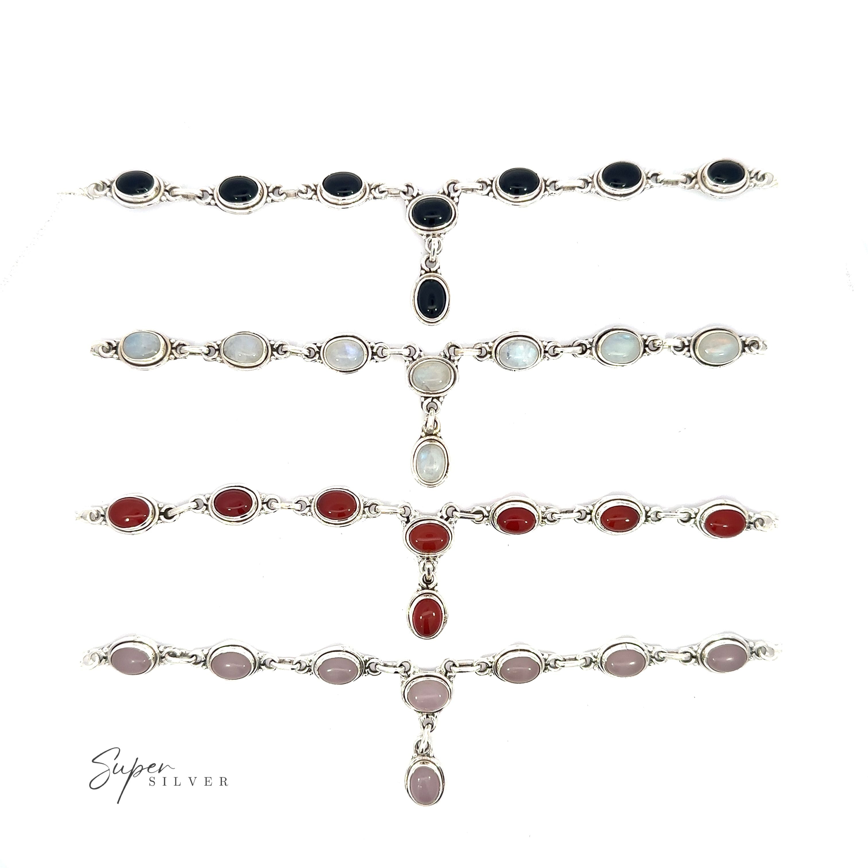 Five Simple Oval Y Necklaces with Gemstones, each adorned with vibrant oval gemstones in black, white, red, and pink, displayed in a row. With a touch of bohemian charm, the text "Super Silver" graces the bottom left corner.