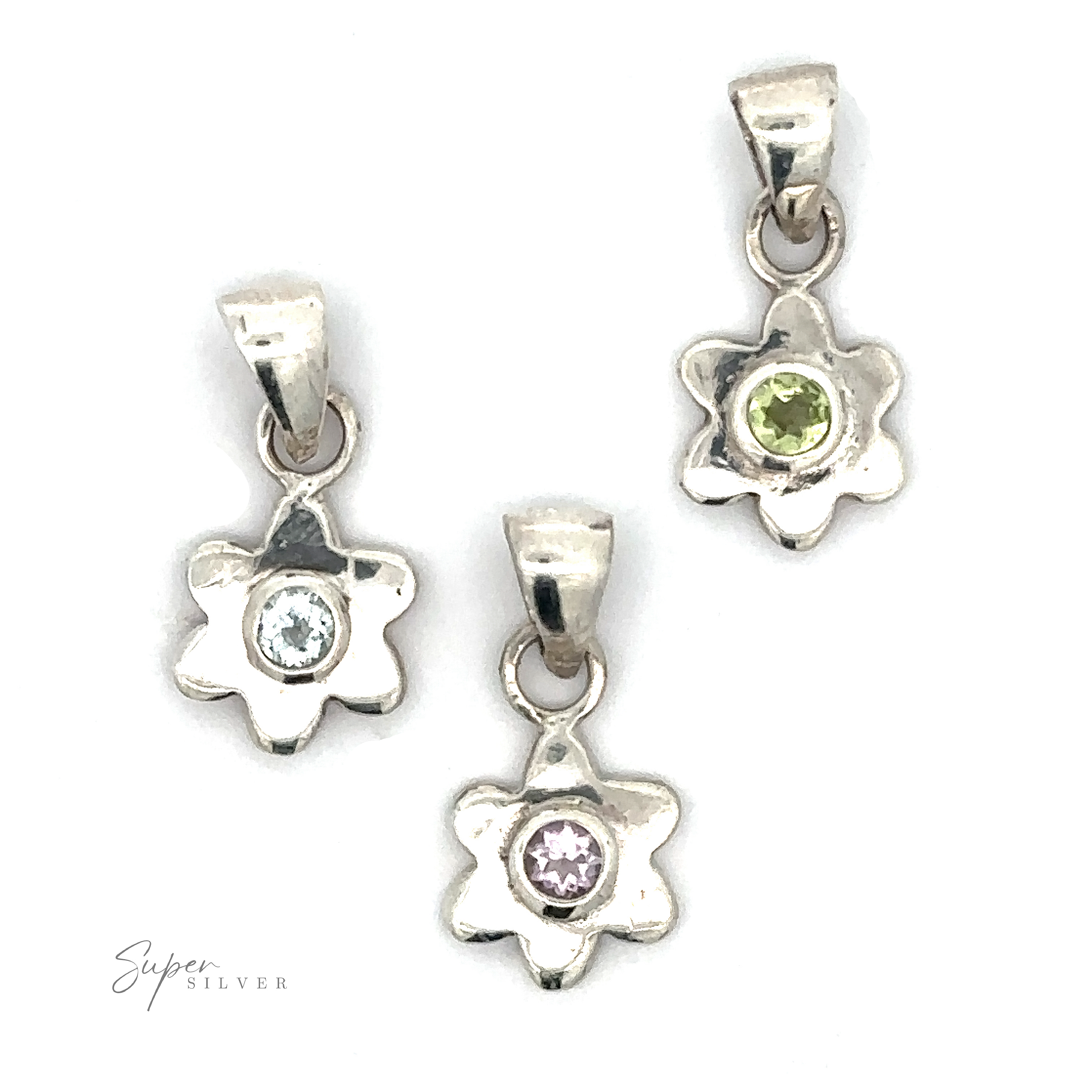 Three Tiny Gemstone Flower Pendants, each adorned with a vibrant gemstone center—one with a light blue stone, one with a pink stone, and one with a green stone—arranged on a pristine white background.