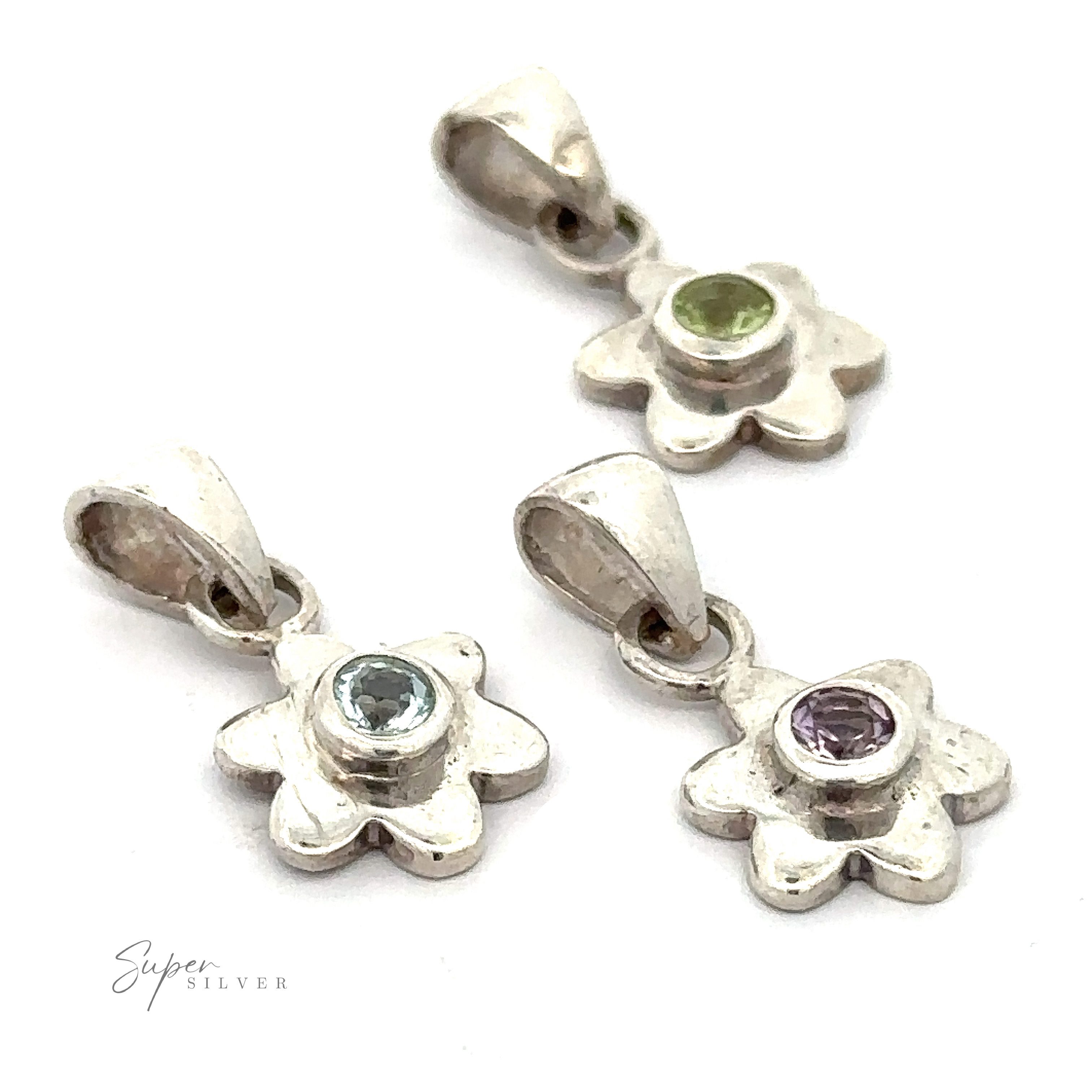 Three Tiny Gemstone Flower Pendants, each featuring a unique gemstone center in green, light blue, and purple, arranged on a white background.