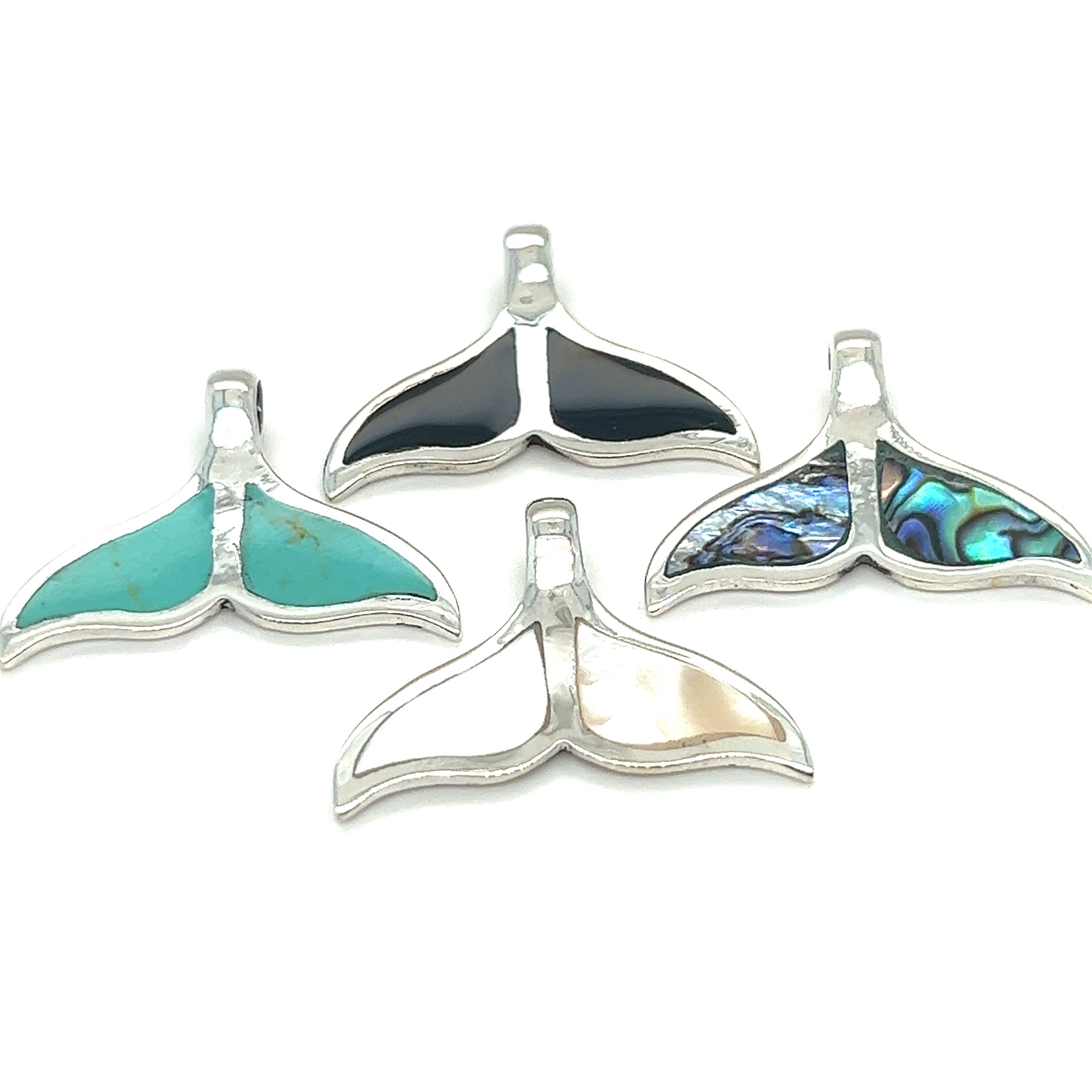 A set of four ocean-themed Inlay Whale Tail Pendants crafted in sterling silver by Super Silver.