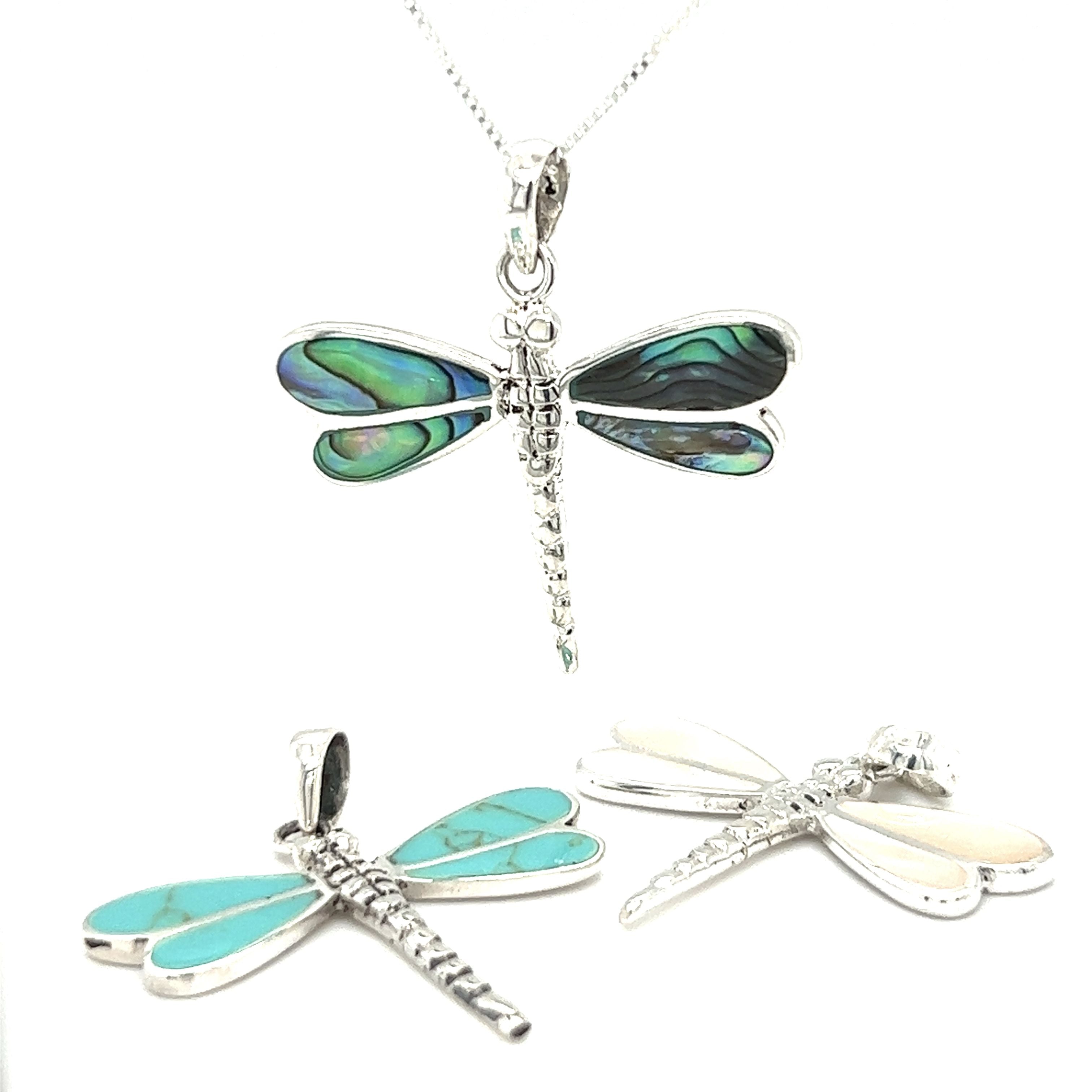 Three Dragonfly Inlay Stone Pendants with mother of pearl accents on a white background by Super Silver.