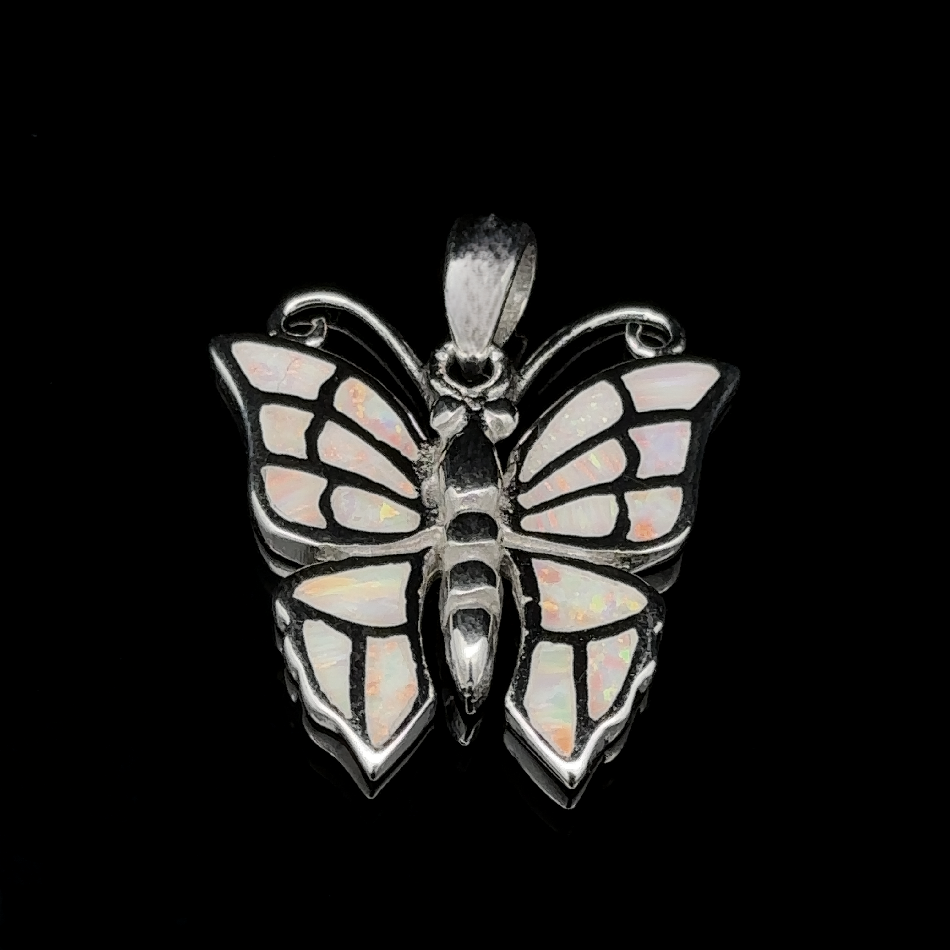 The Lab-Created Opal Butterfly Pendant, exquisitely crafted from sterling silver, showcases iridescent lab-created opal wings set against a sleek black backdrop.