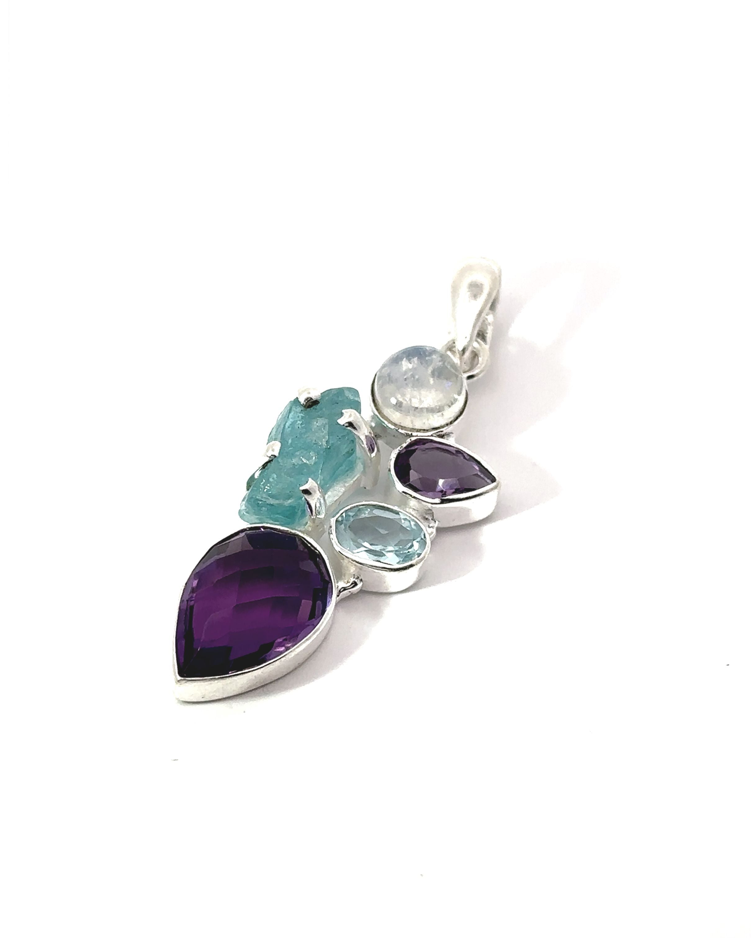 The Amethyst Multi Stone Pendant is a captivating bohemian jewelry piece, showcasing a striking amethyst teardrop, exquisite blue stones, and a clear gem beautifully set in silver against a white background.