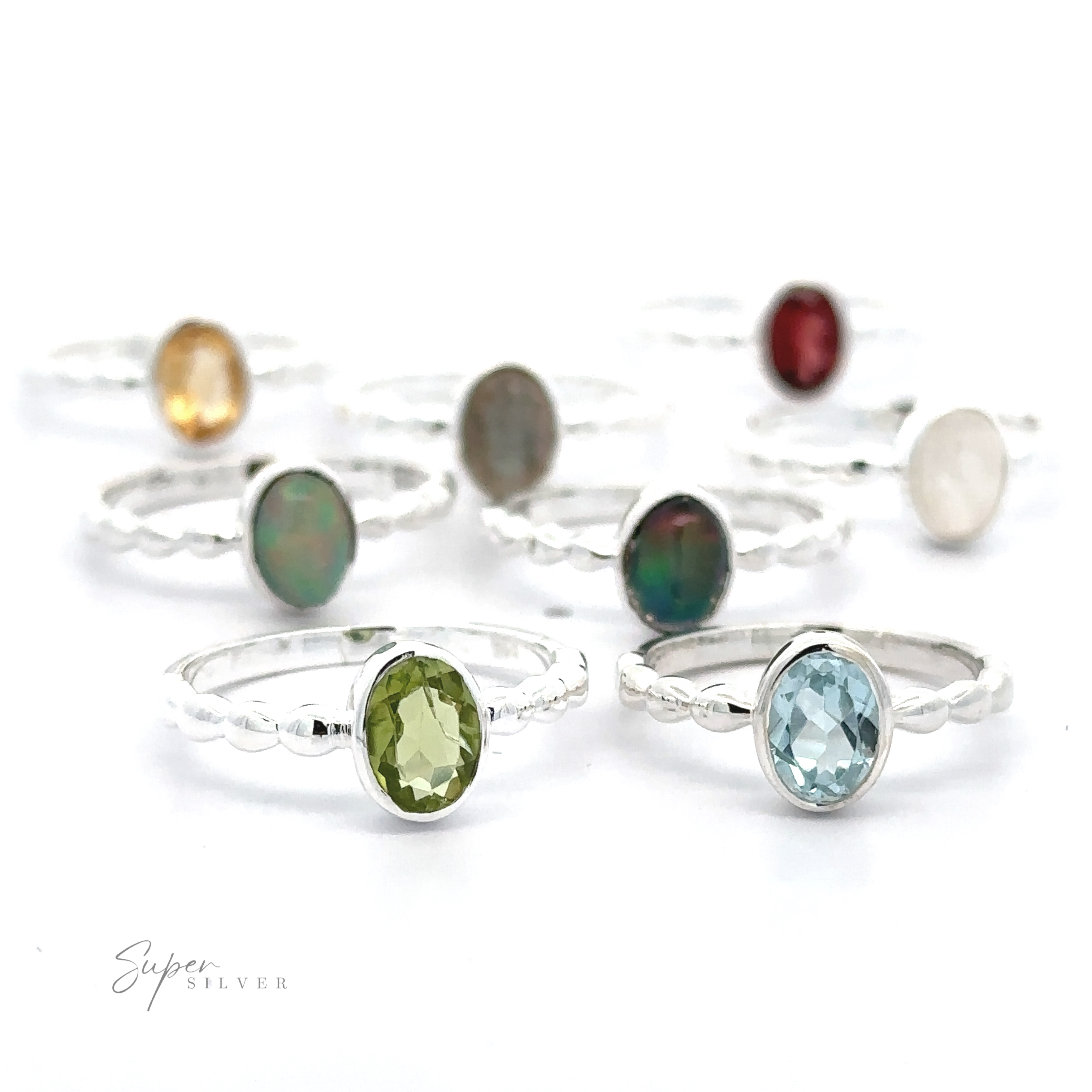 A collection of Oval Gemstone Rings with Beaded Bands displayed on a white background.