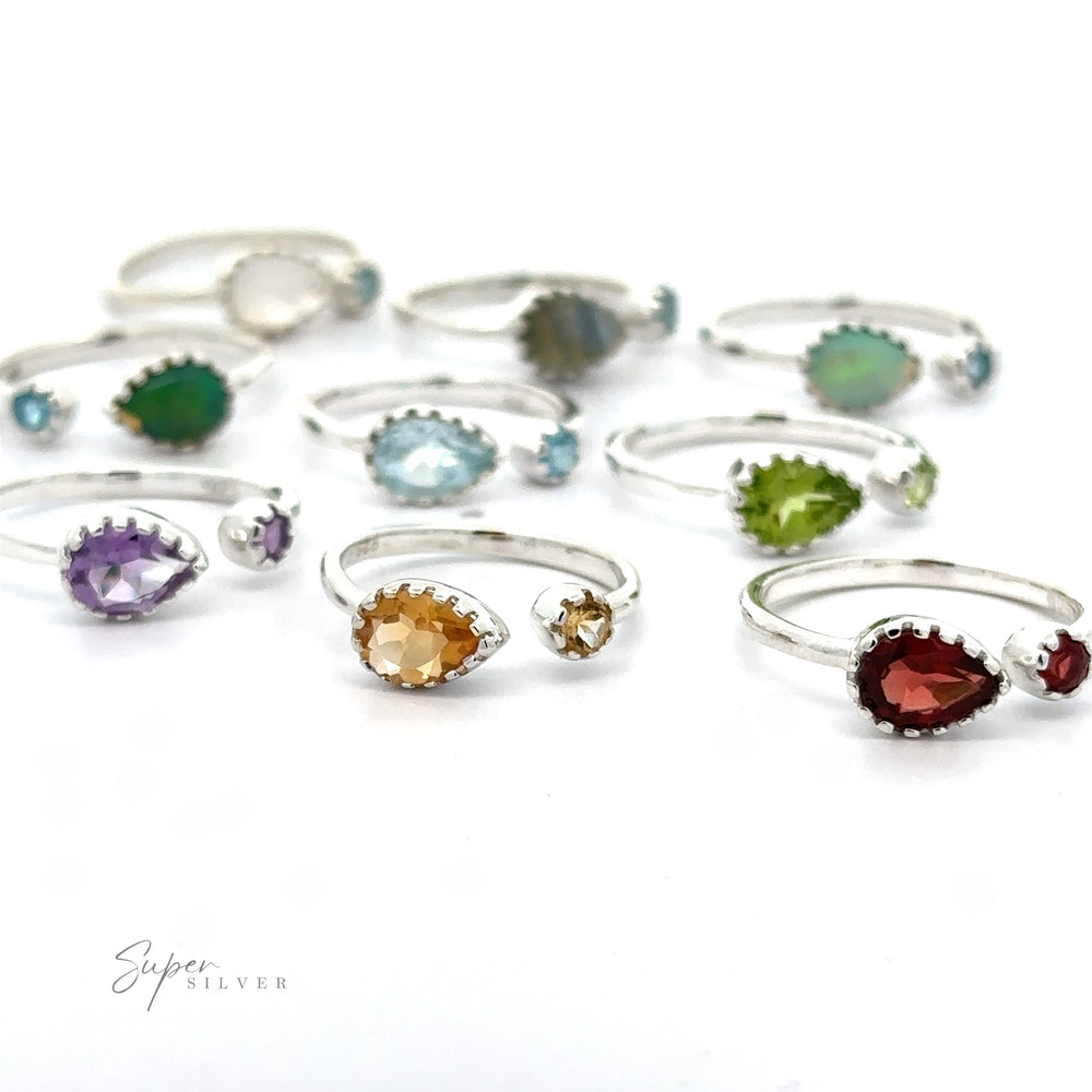 A collection of Dainty Adjustable Gemstone Rings with Two Stones, each featuring different colored gemstones, arranged on a white surface.