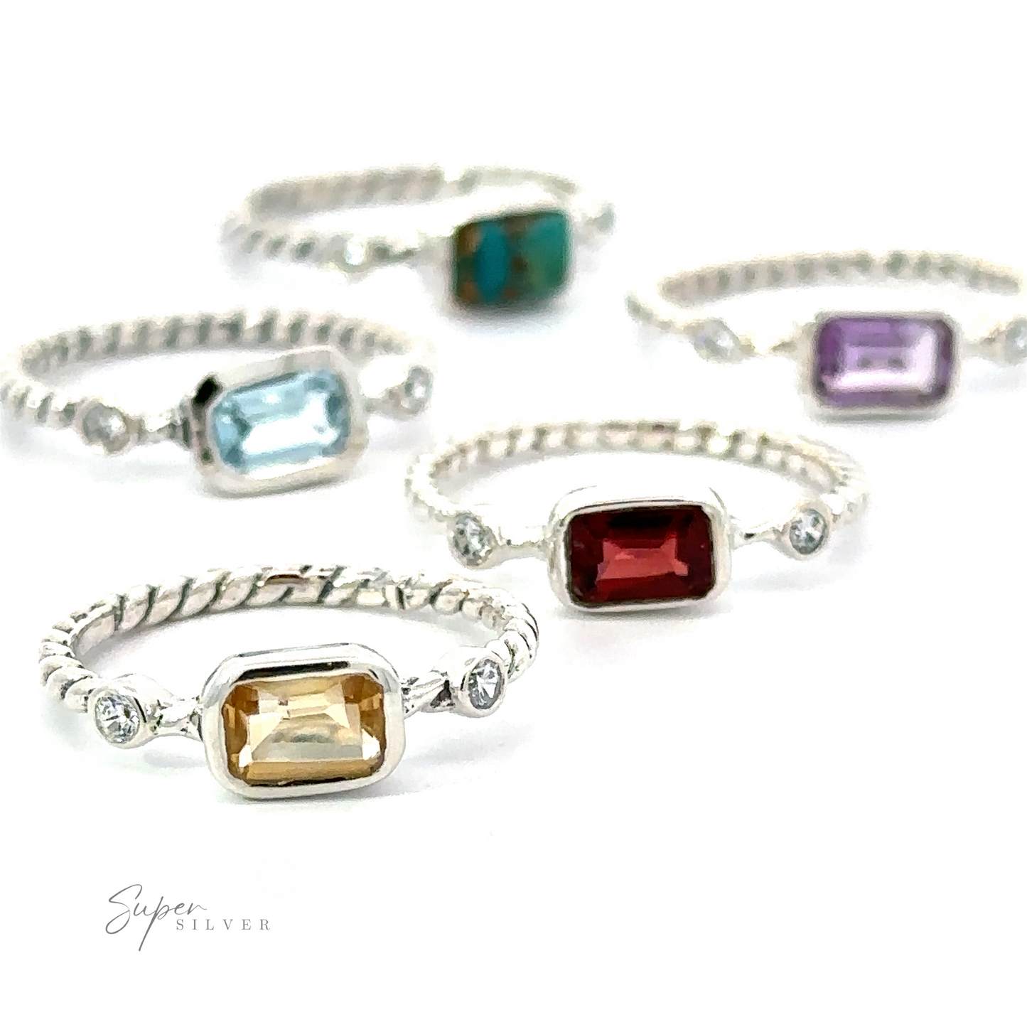 Assorted gemstone rings with different cuts and settings, including a Rectangle Gemstone Ring with Twisted Band, displayed on a white background.