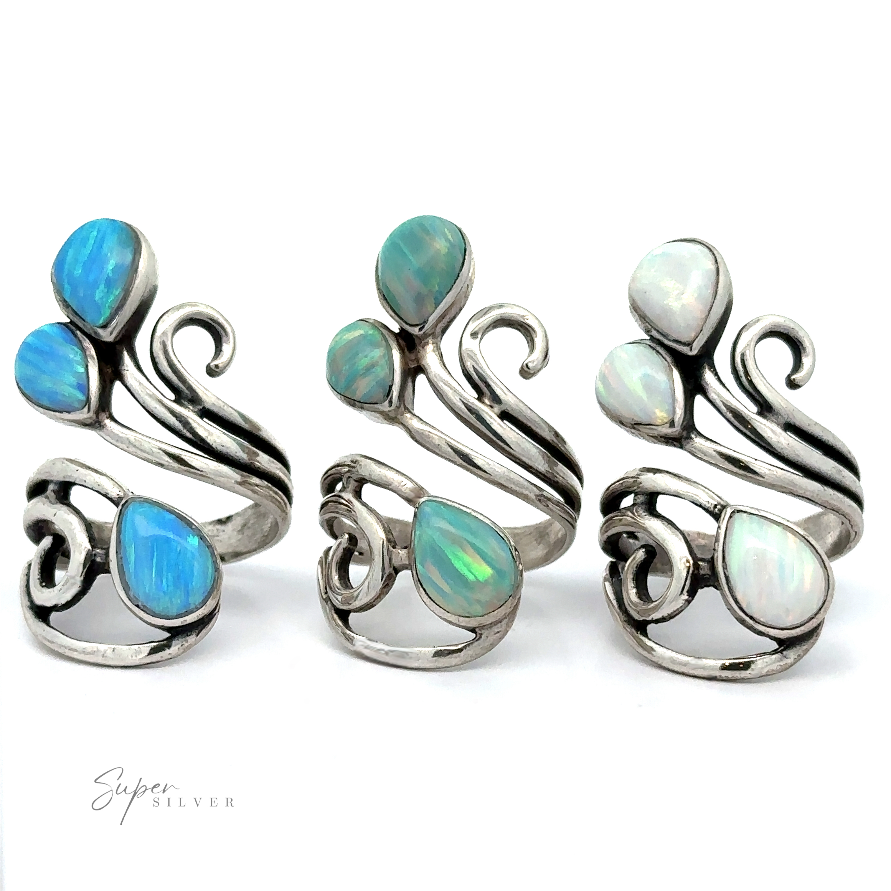 Three silver Stunning Wrap-Around Opal Rings featuring ornate designs with blue, green, and white opal stones on a white background. Each handcrafted in America ring has a unique swirl pattern and is labeled "Super Silver" at the bottom left. Made from .925 sterling silver, these Stunning Wrap-Around Opal Rings are truly exquisite.