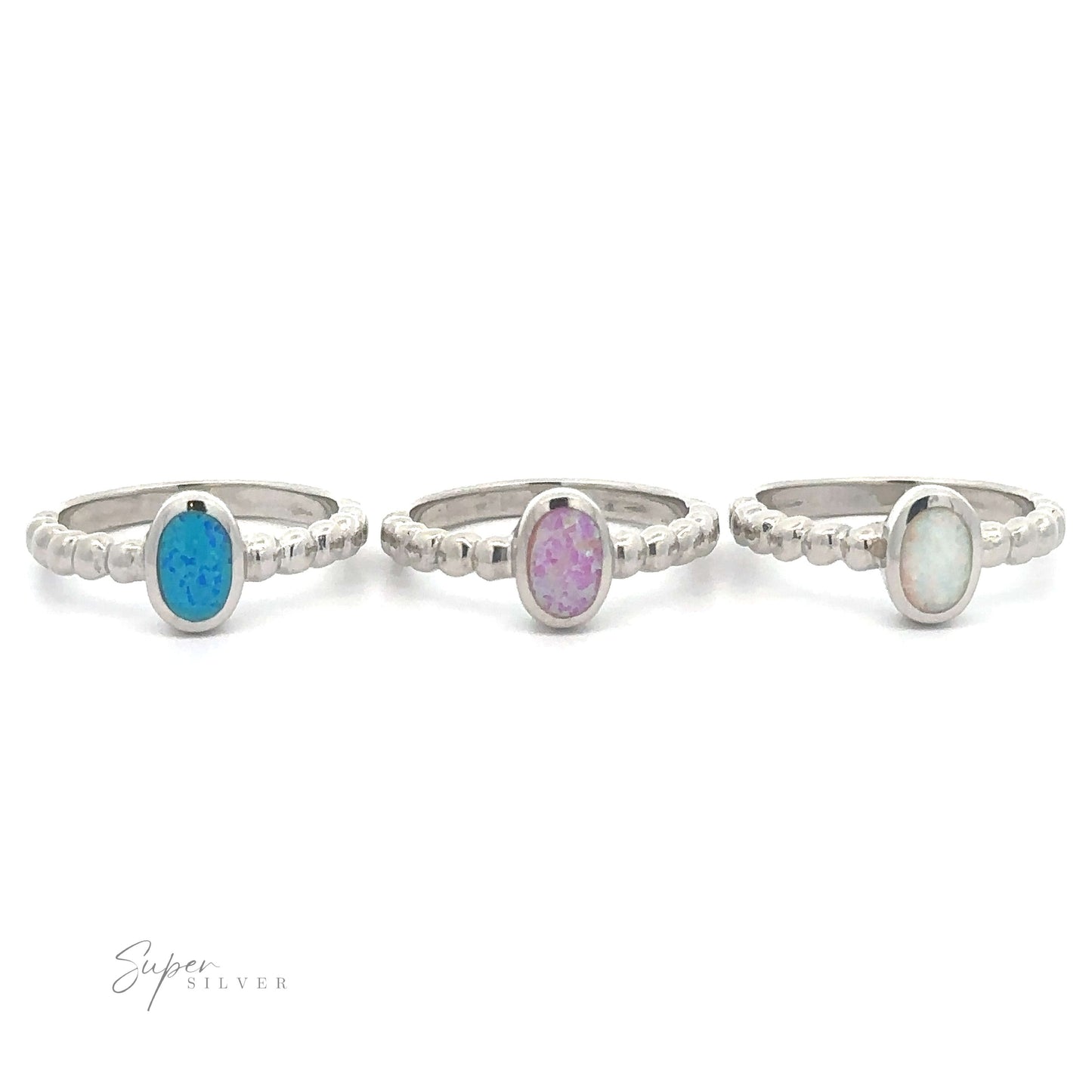 
                  
                    Three sterling silver rings with different colored oval lab opal gemstones on a white background.
                  
                