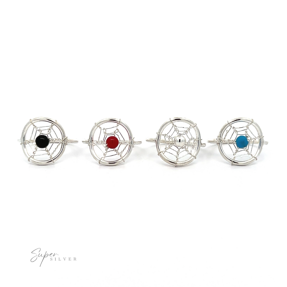 
                  
                    Four Wire Dreamcatcher Rings with Bead centers in black, red, and blue, displayed on a white background.
                  
                