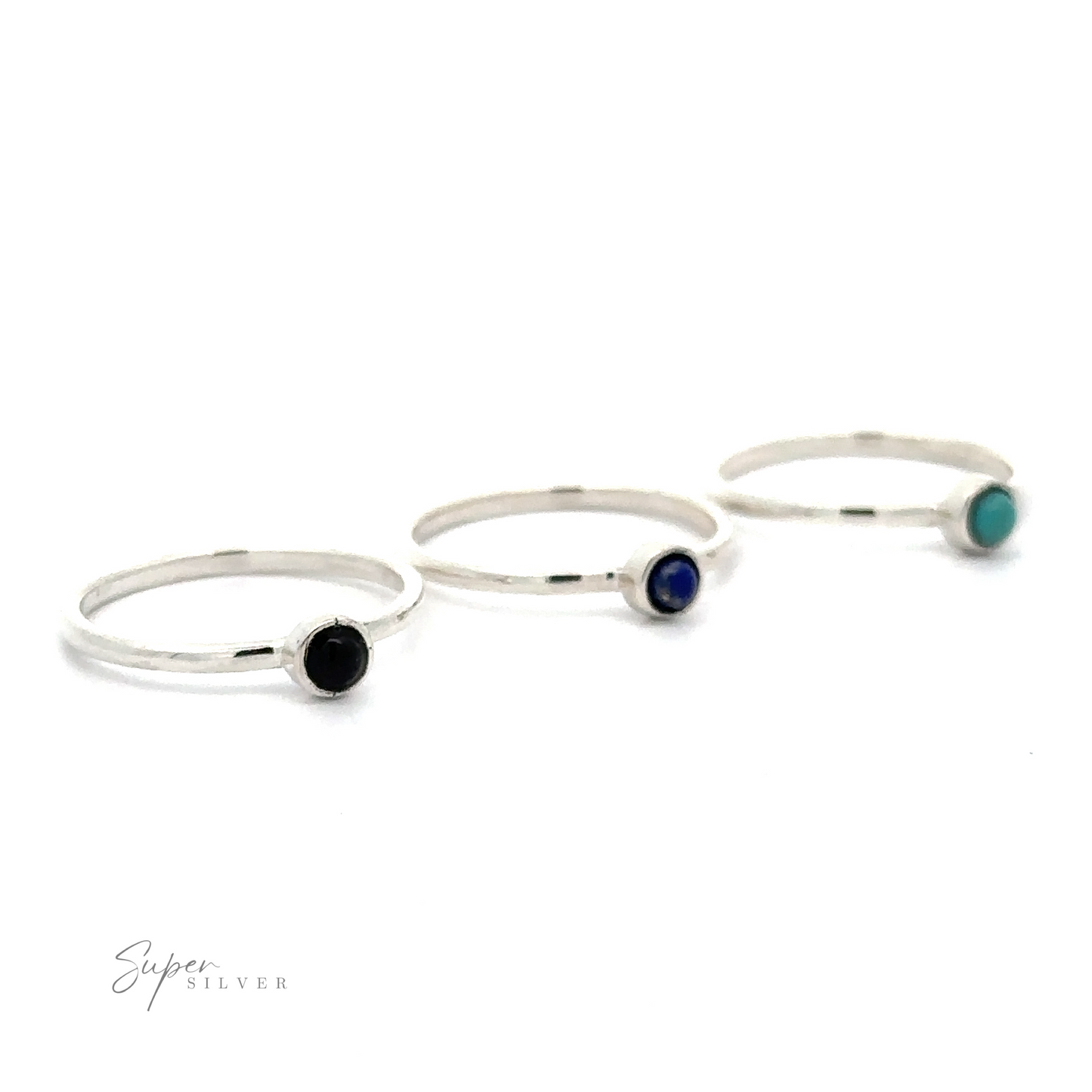 Three thin sterling silver rings with small round stones; one black, one blue, and one turquoise. The words "Dainty Stackable Round Gemstone Ring" appear in the bottom left corner. Perfect for minimalist fashion, these stackable rings are both elegant and versatile.