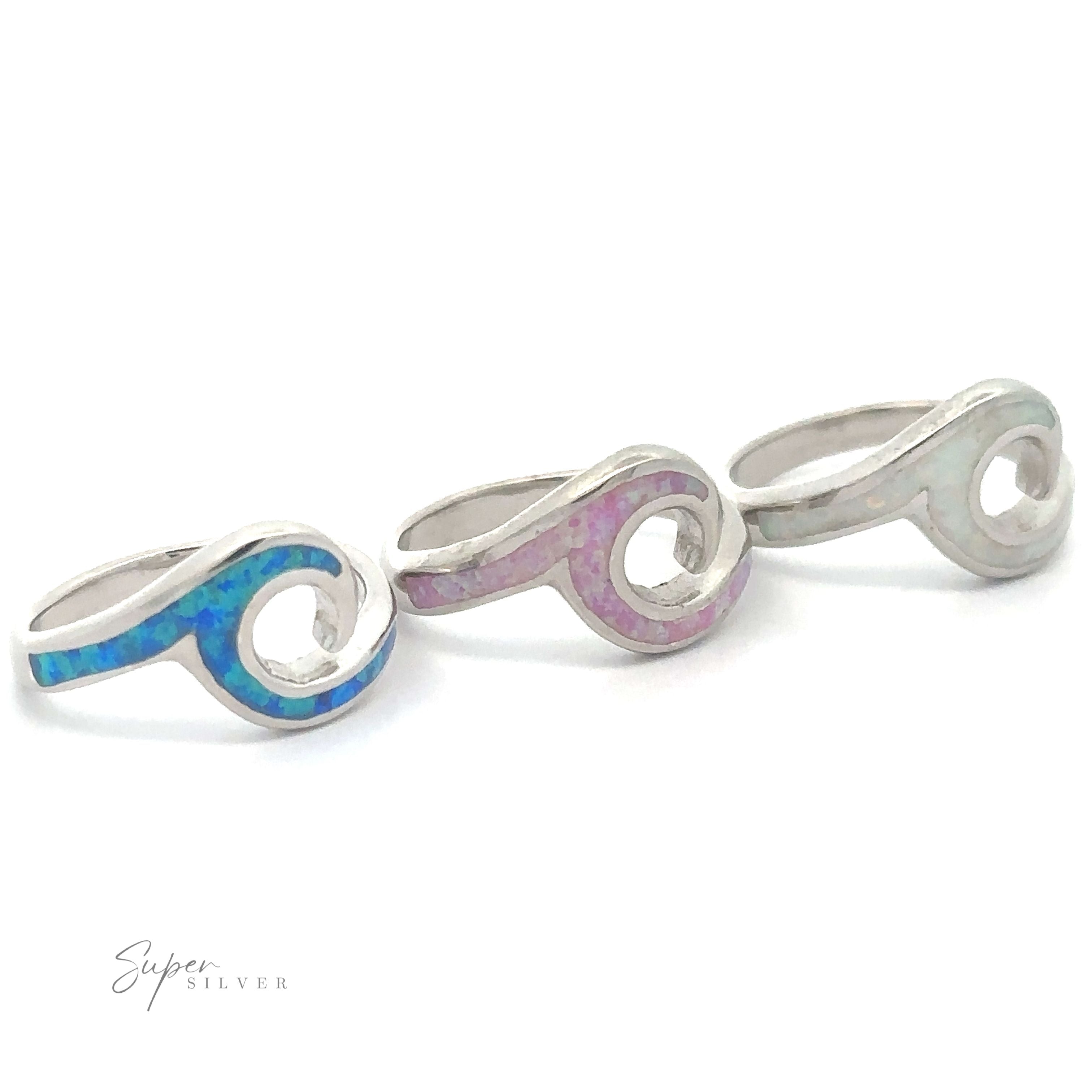 Three Lab-Created Opal Wave Bands with designs inlaid with blue and pink fire-opal materials.