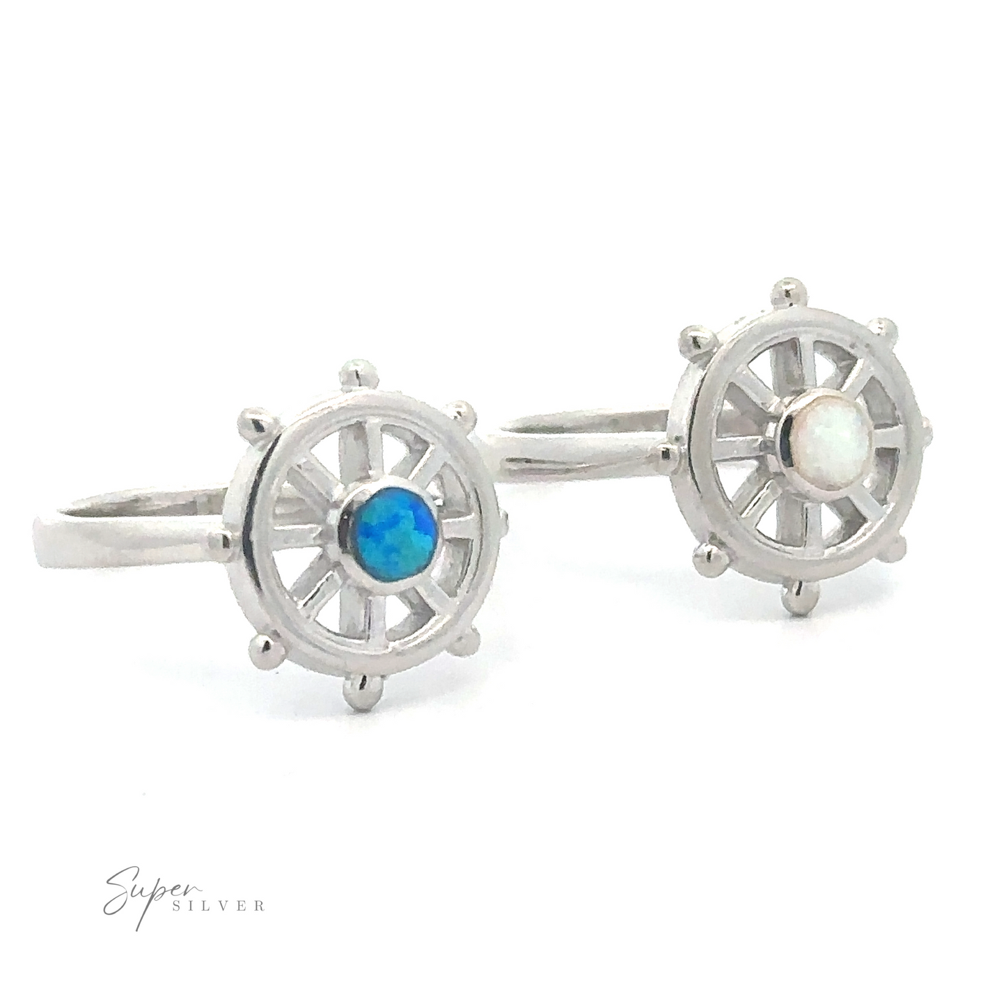 Silver ship wheel ring-shaped earrings with lab opal stones at their centers.