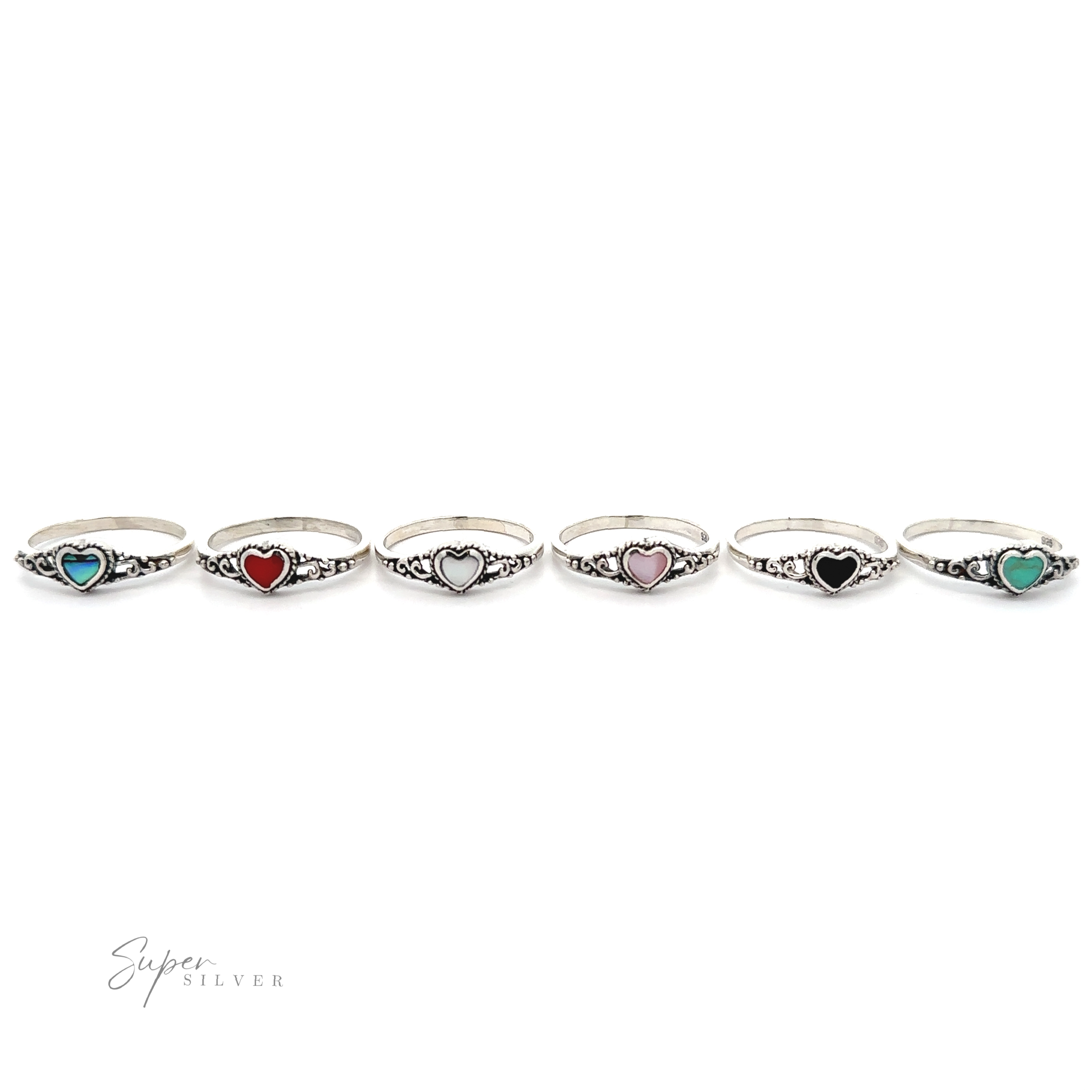 A row of Dainty Heart Filigree Rings with Inlaid Stones, each featuring a Bali-style filigree design with different colored stones.