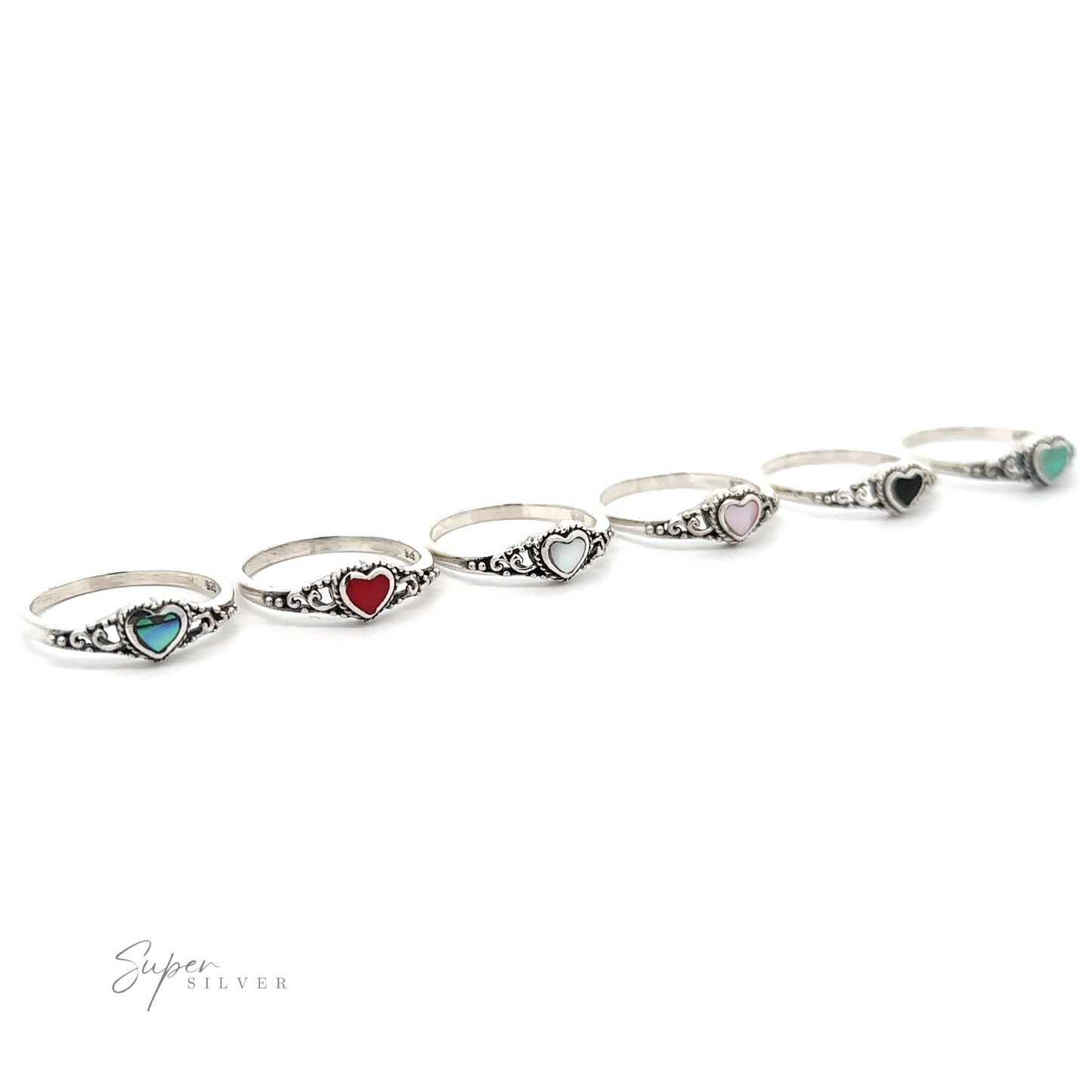 A row of sterling silver rings with different colored stones, including a Dainty Heart Filigree Ring with Inlaid Stones.