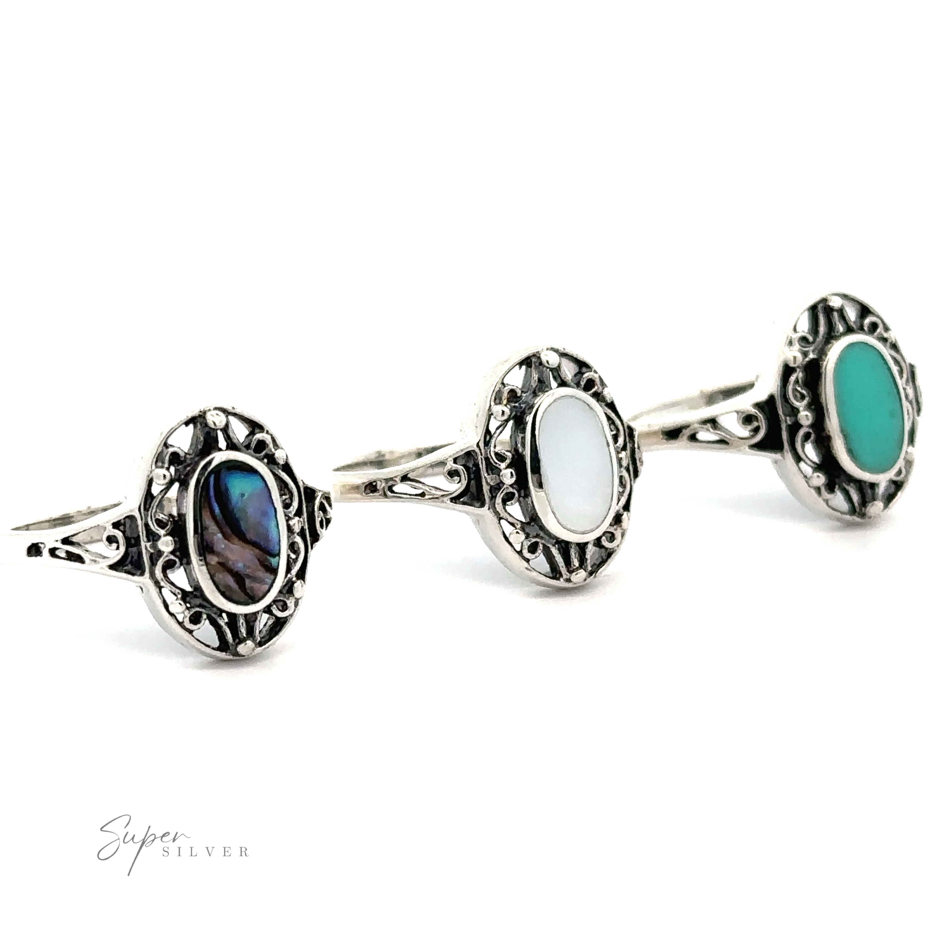 Three sterling silver rings with Oval Inlay Stones with Swirl Filigree Borders.