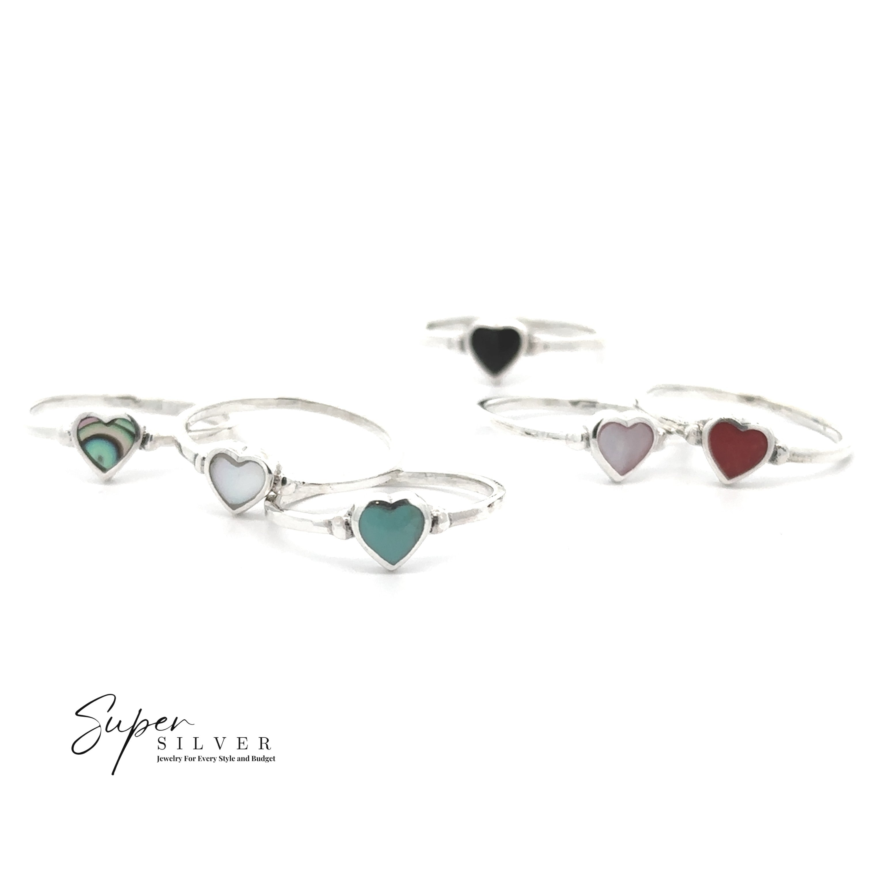 Five Dainty Inlaid Heart Rings, each in sterling silver with heart-shaped stones in green, turquoise, black, pink, and red, are displayed on white. The "Super Silver" logo is at the bottom left. Add a pop of color to any style!.