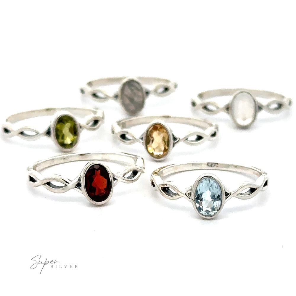 Assorted silver Dainty Oval Gemstone Rings with various sparkling oval gemstones displayed against a white background.