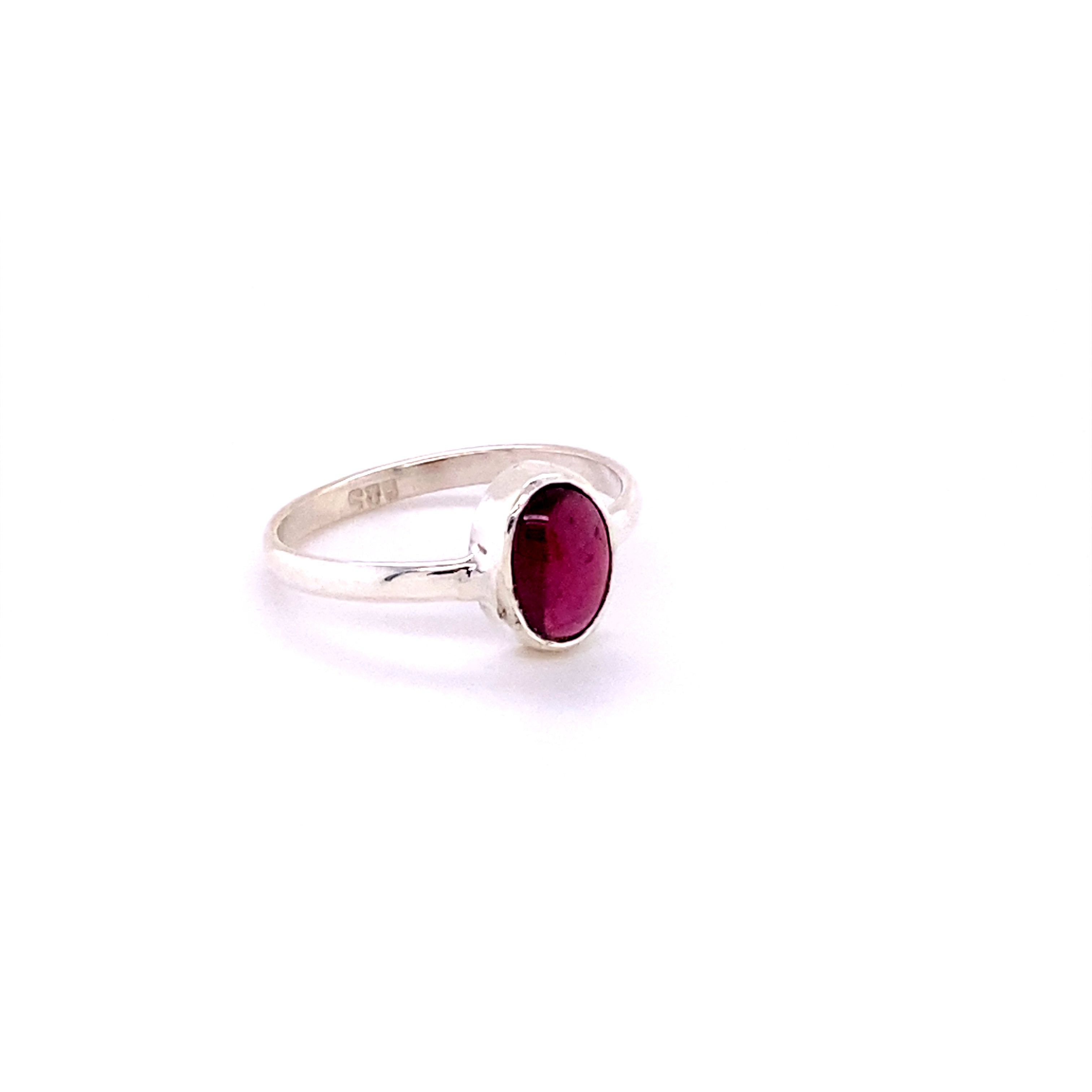 Simple Sterling Silver ring with an oval pink gemstone set in a plain bezel, isolated on a white background.