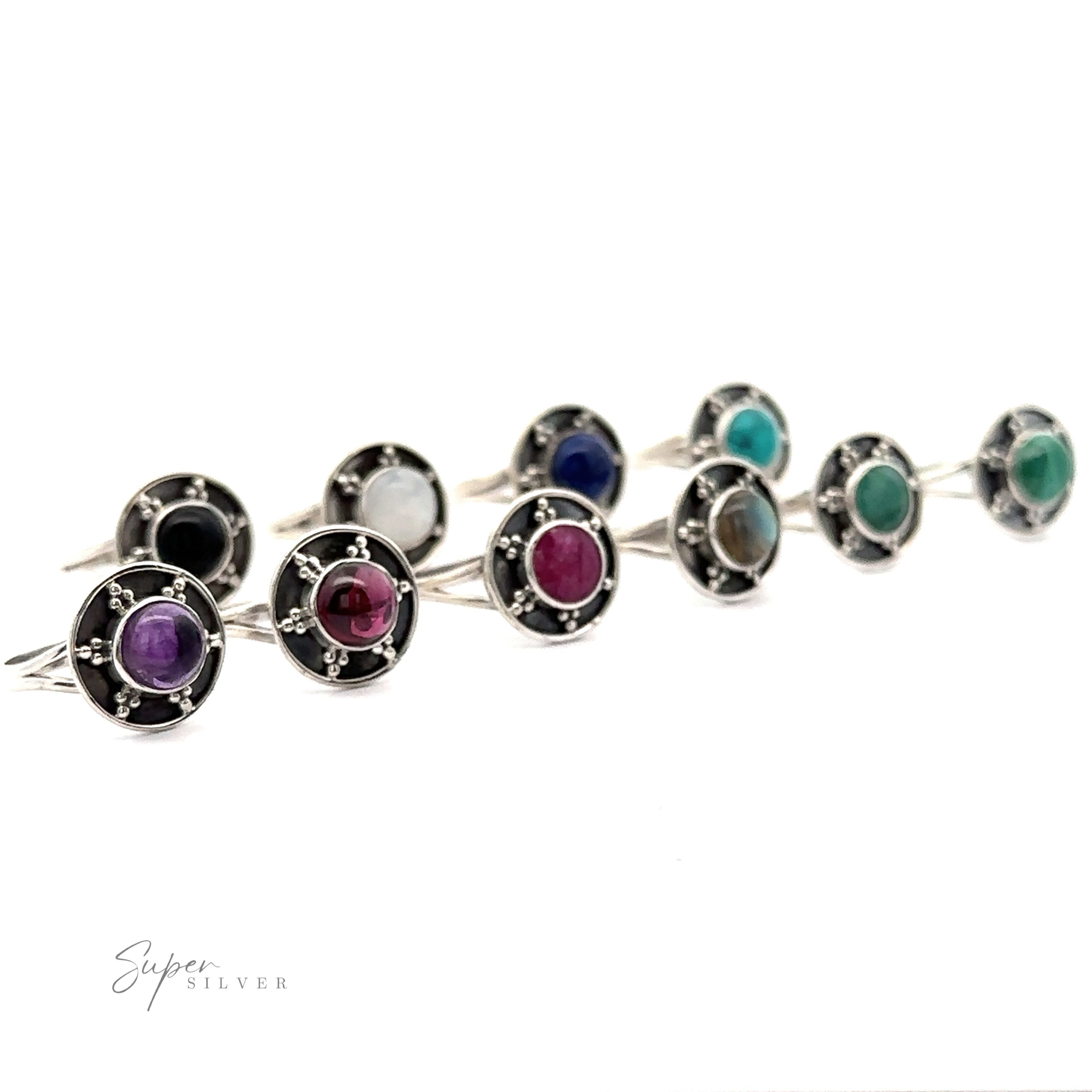 A collection of nine Gemstone Rings With Unique Oxidized Design, each showcasing a different colored gemstone set in an oxidized silver circular mount, arranged in three rows against a white background.