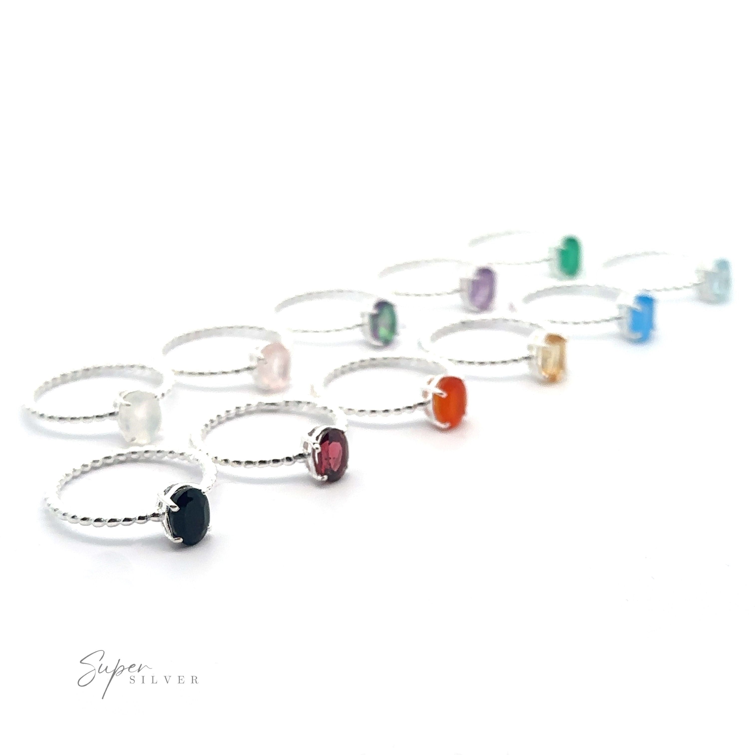 A collection of Stunning Oval Gemstone Rings with Beaded Bands, including amethyst, displayed in a row on a white background.