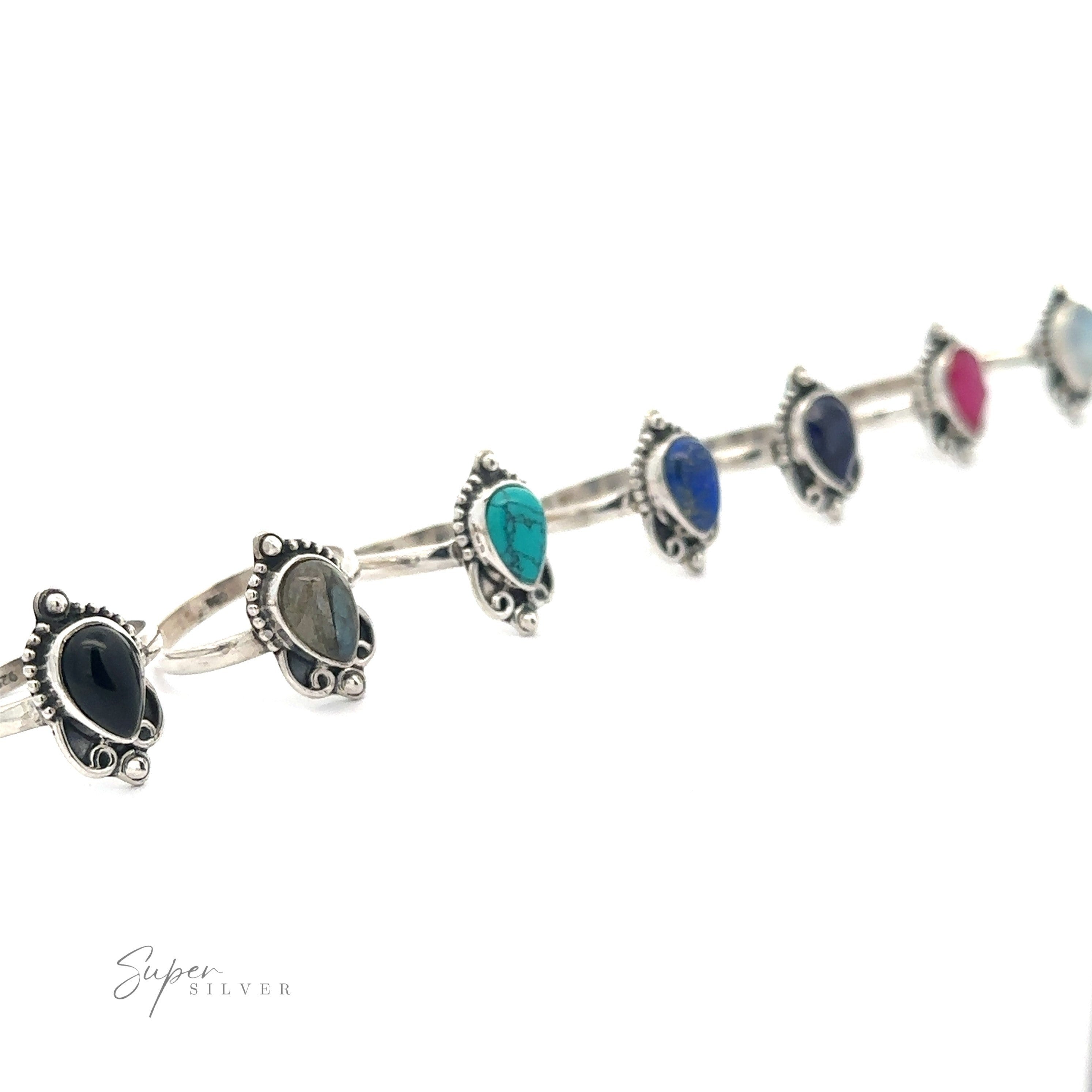 Vintage Inspired Teardrop Gemstone Ring crafted from .925 Sterling Silver, featuring a pattern of multicolored gemstones including turquoise, sapphire, and ruby, displayed against a white background.