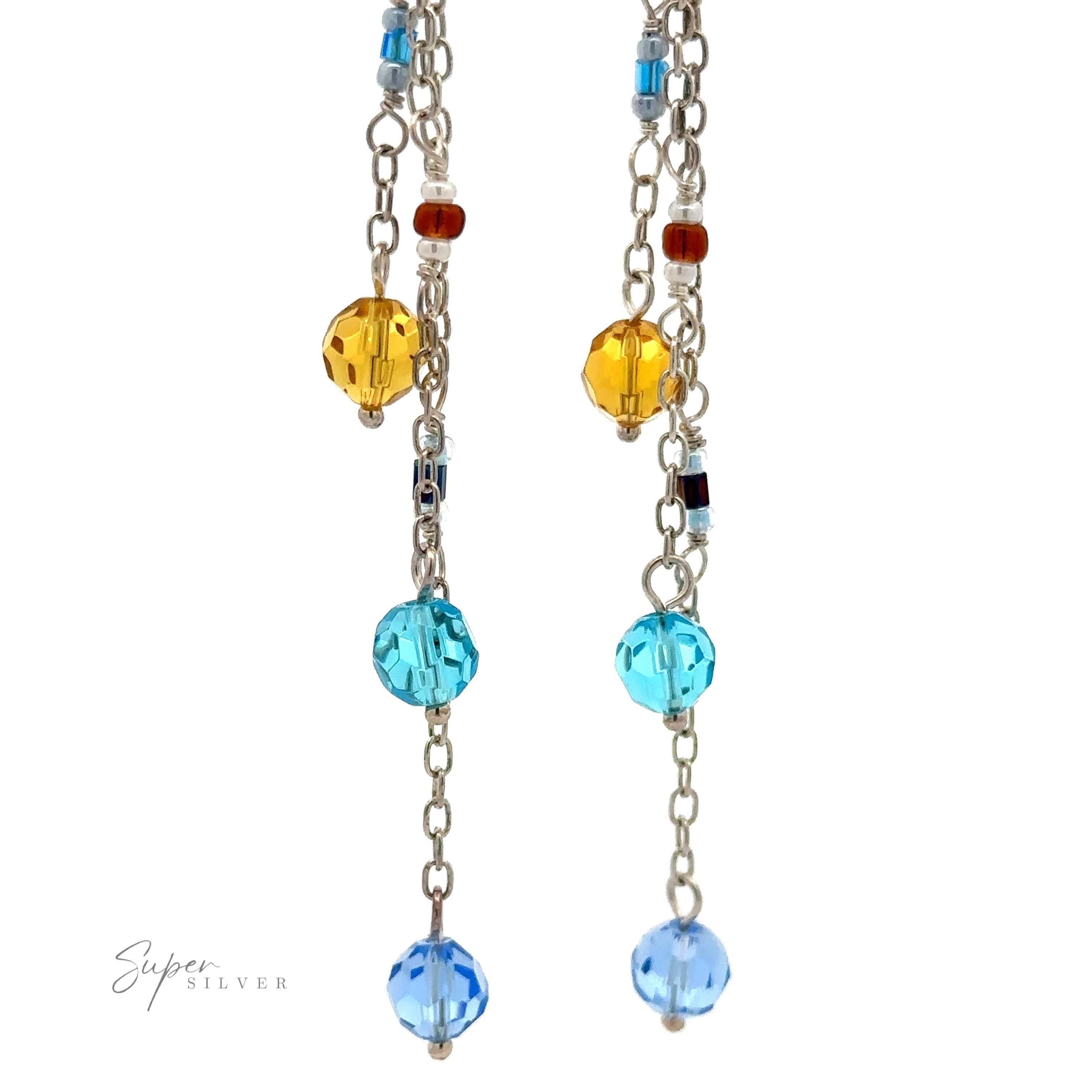 Dangle earrings with silver chains featuring multicolored beads in blue and yellow crystal. The brand name "Super Silver" is displayed in the bottom left corner.