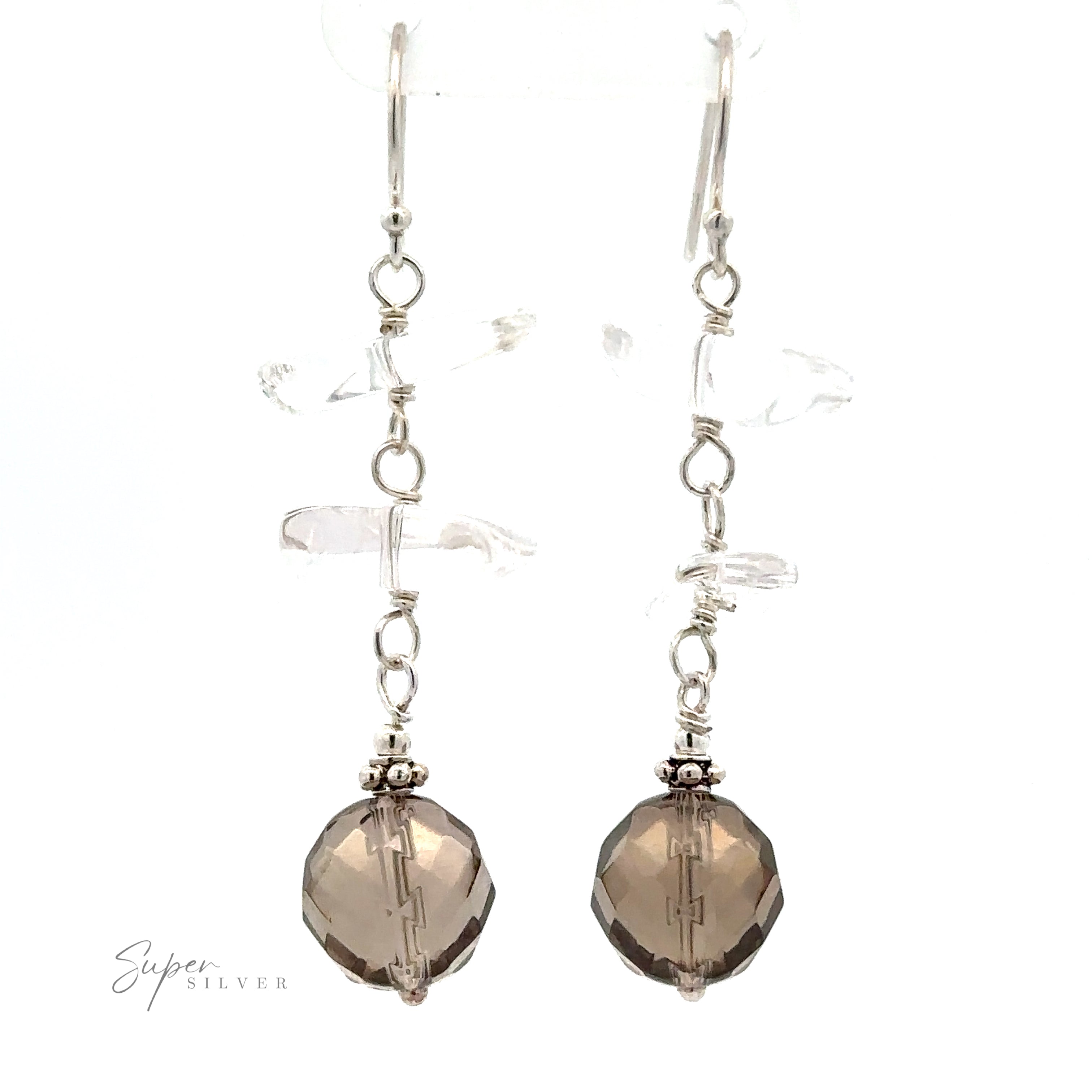 A pair of Earrings with Clear and Faceted Gray Beads featuring translucent and multicolored beads, complemented by larger smoky brown faceted beads at the ends. Crafted with thin sterling silver hooks, they offer a touch of elegance. "Super Silver" text is shown in the bottom left corner.