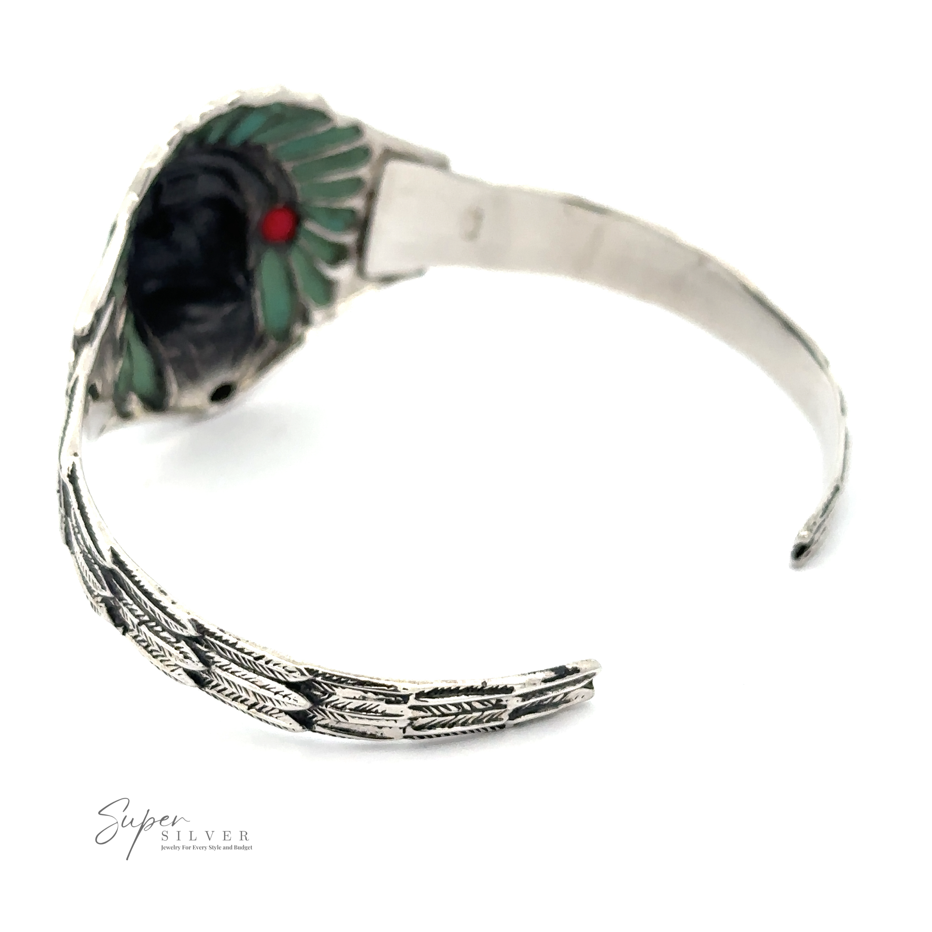 A Chief Head Inlay Stone Cuff with a feathery design, featuring green and red accents and partially open, positioned on a white background. The Super Silver logo is visible in the bottom left corner, paying homage to Native American heritage.
