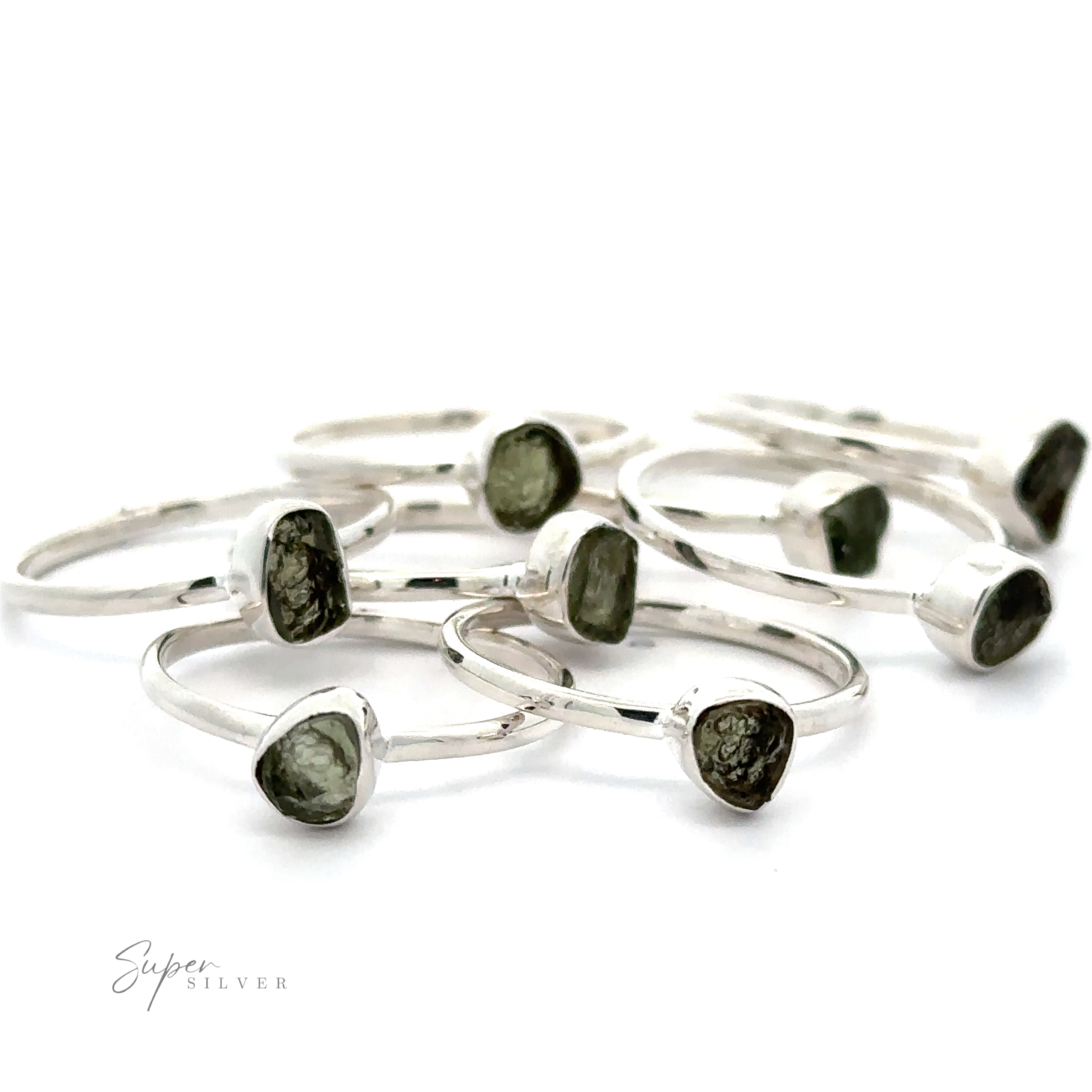 A collection of sterling silver rings with rough-cut green Raw Moldavite Rings, displayed against a white background.
