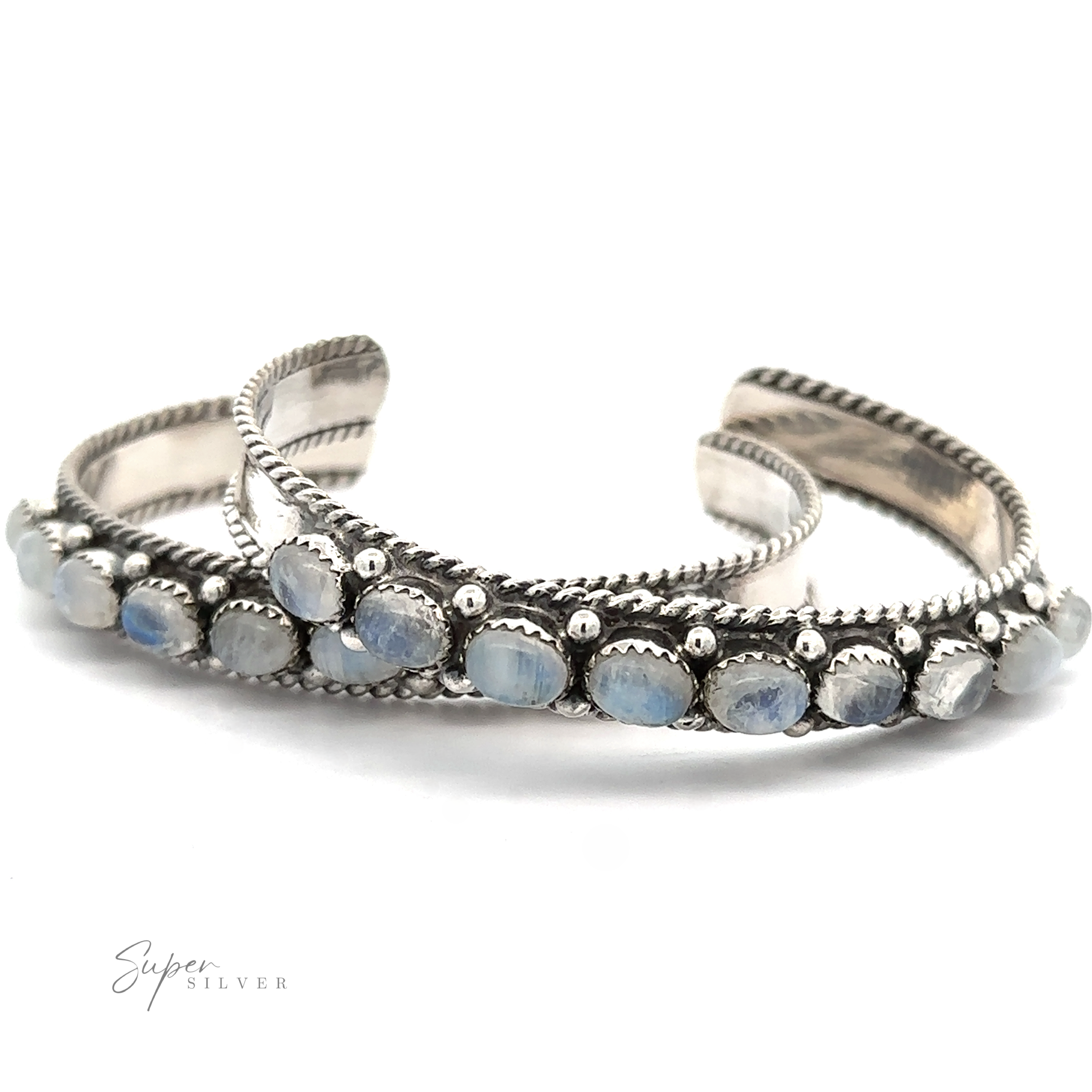 Two intricately designed sterling silver bracelets adorned with blue stones are positioned side by side against a white background. The word "Super Silver" is visible in the lower left corner. These Oval Moonstone Cuff Bracelets are believed to possess unique metaphysical properties.