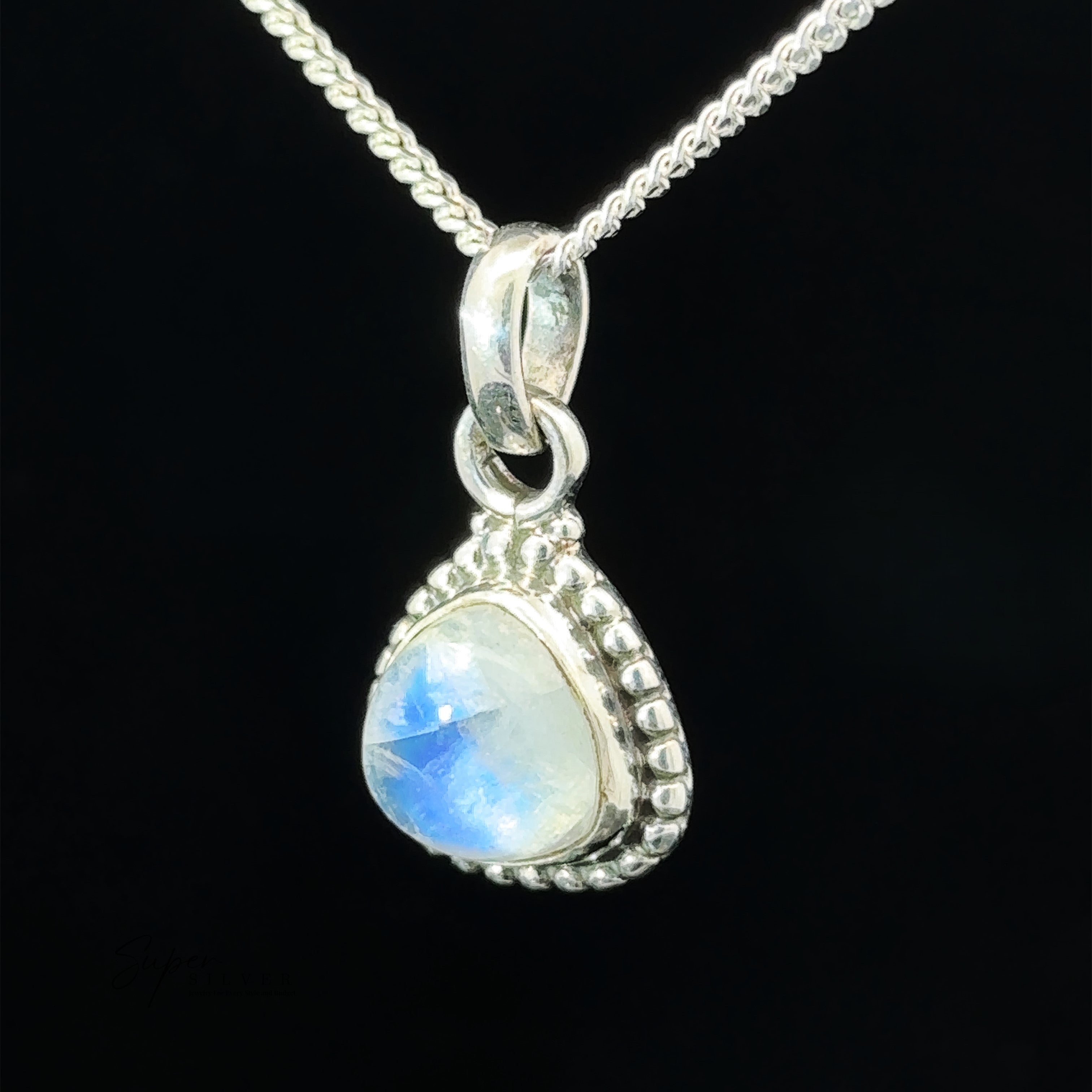 A close-up image of a Beautiful Triangular Shape Stone Pendant With Beaded Design set in an ornate bezel with small bead detailing. The intricate beaded design enhances the background, which is black, perfectly highlighting the shimmering gemstones.