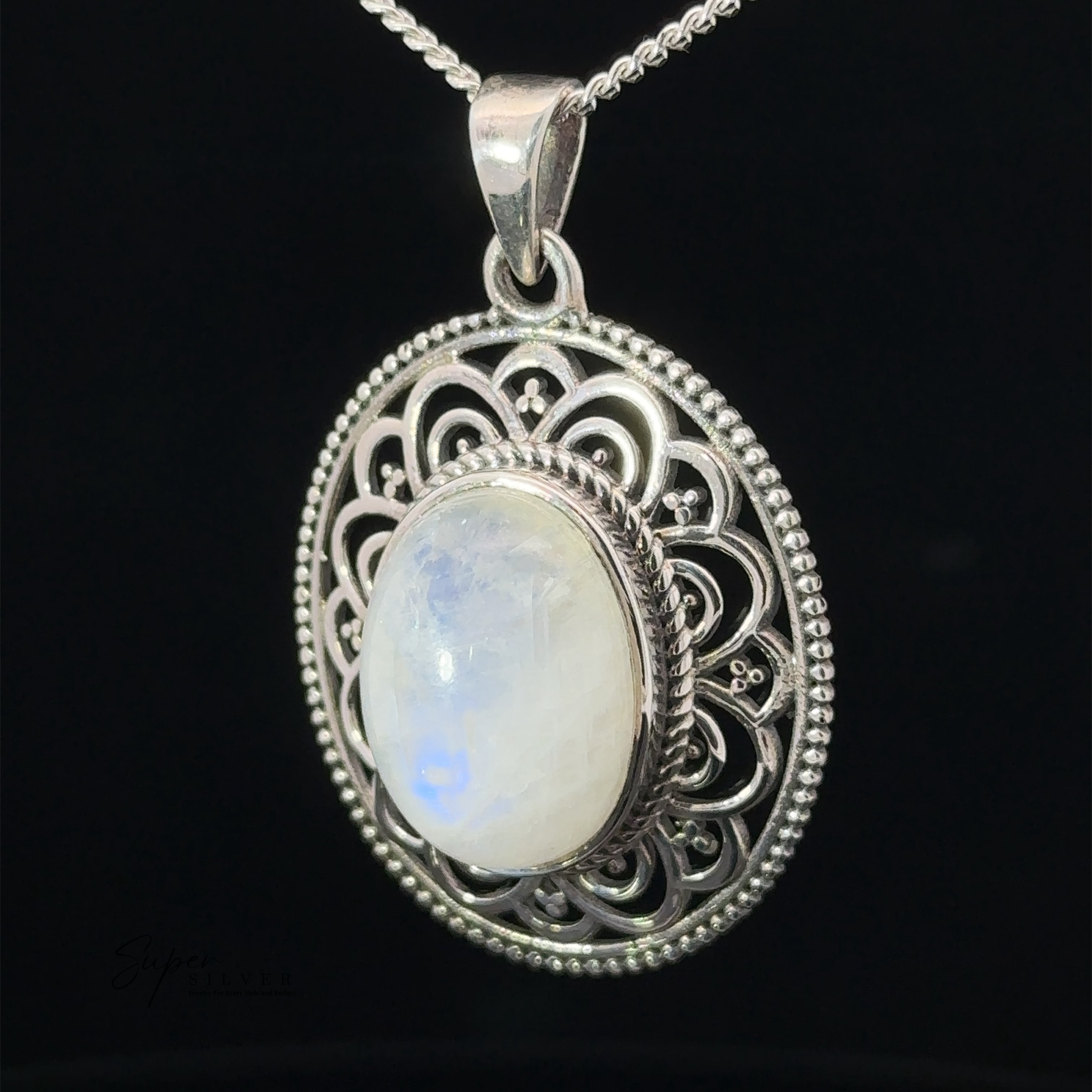 Close-up of an Oval Stone Pendant with Filigree Border, featuring intricate filigree details, hanging on a silver chain against a black background.