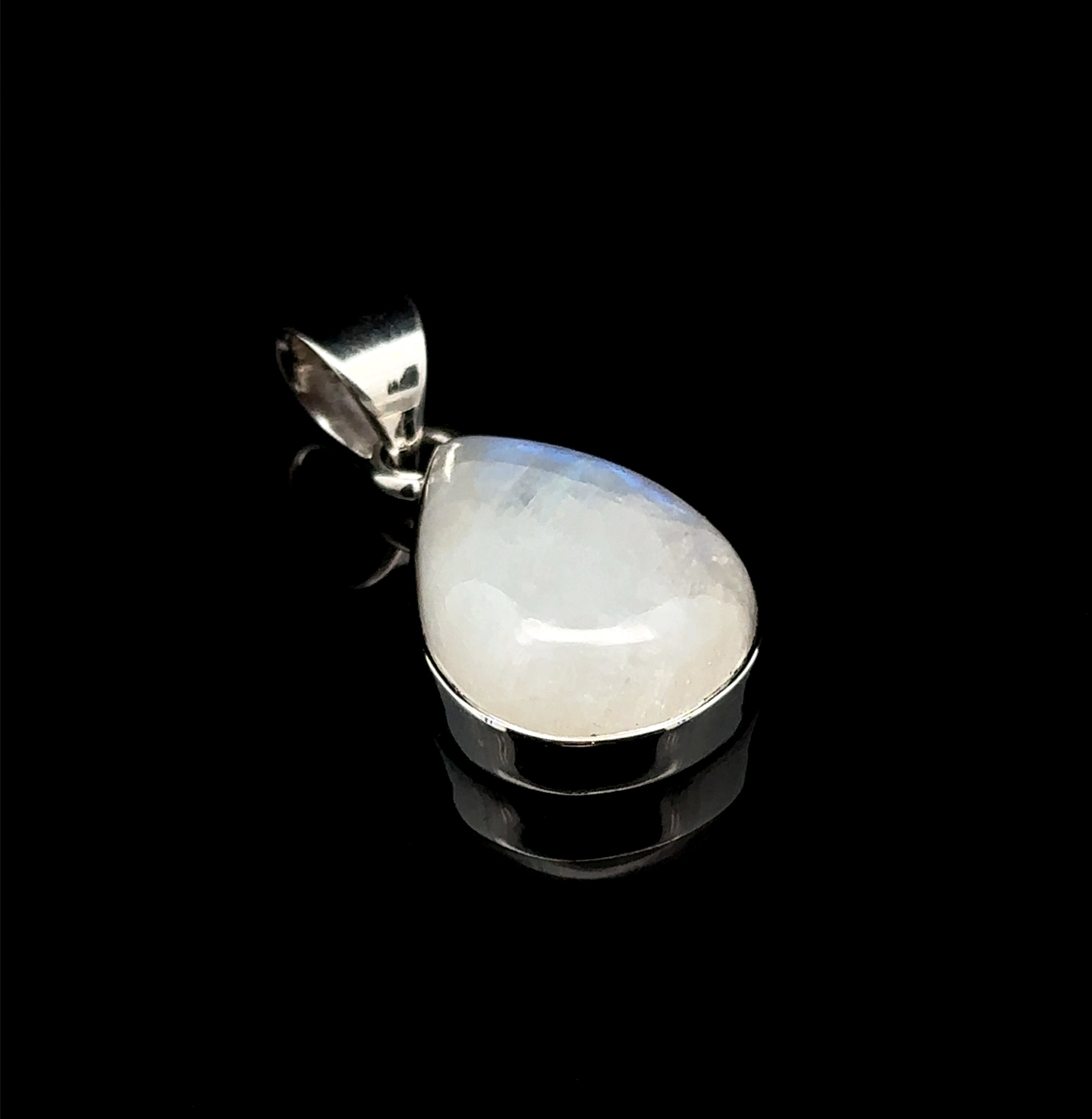 The Simple Teardrop Moonstone Pendant, set in sterling silver and displayed on a black background, beautifully showcases the mystical energy of the moonstone.
