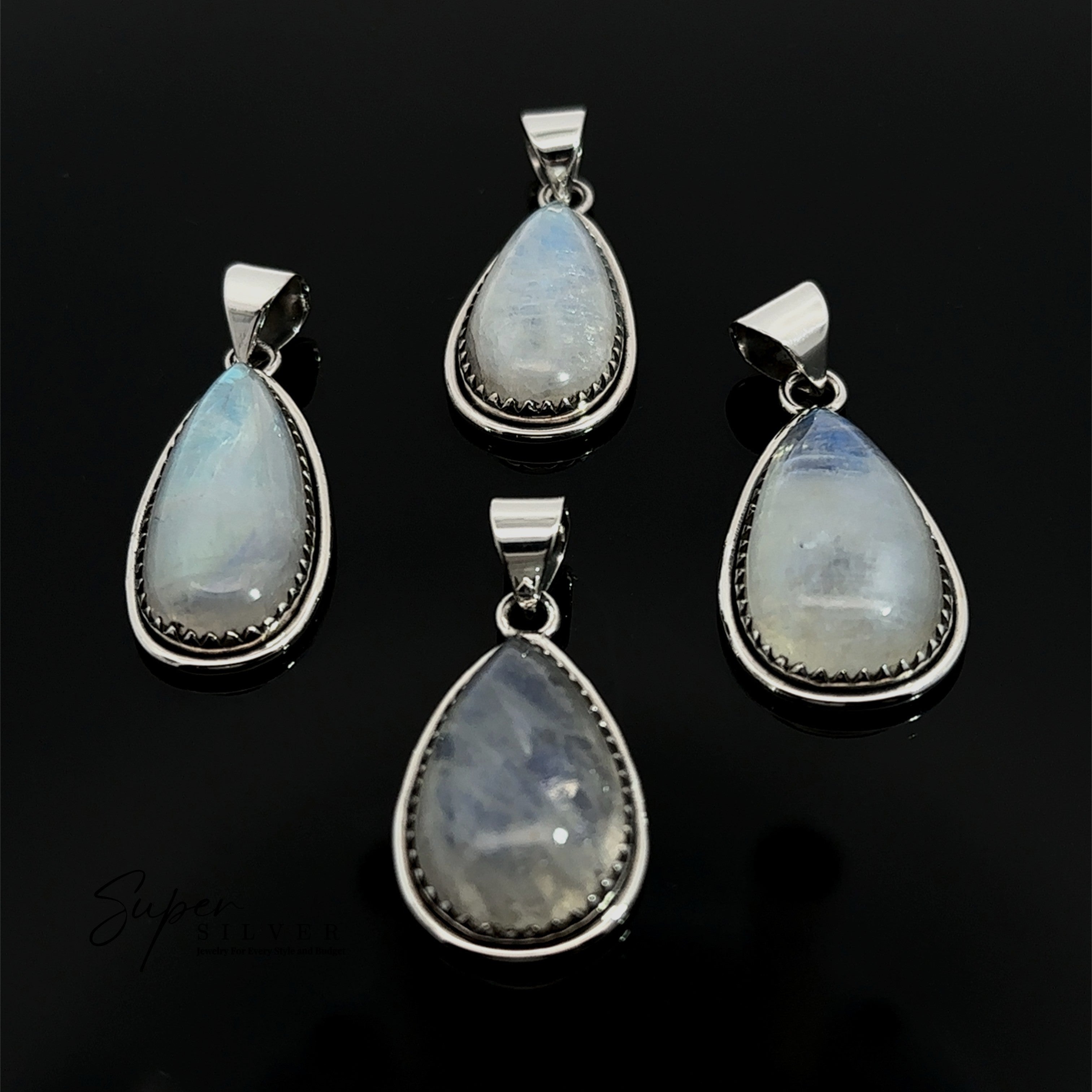 Four Teardrop Moonstone Pendants, each set in sterling silver with subtle boho details, are displayed on a black background.